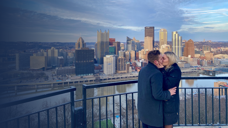 Henne couple Marc and Lisa overlooking Pittsburgh kissing