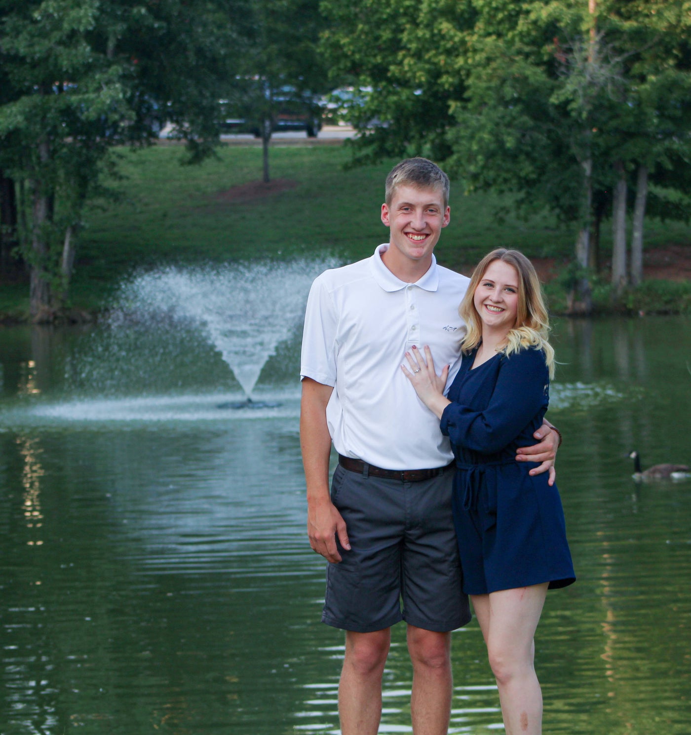 Henne Engagement Ring Couple Ian & Maddi Smiling in Front of a Water Fountain