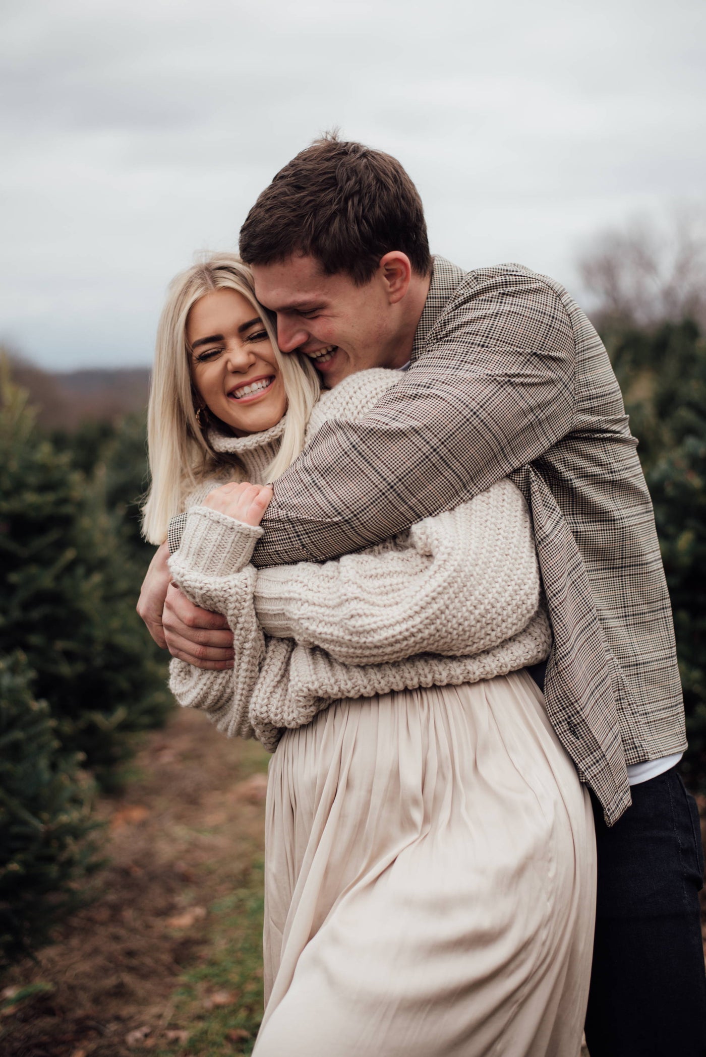 ne Engagement Ring Couple James & Kelsey Embrace at a Christmas Tree Farm