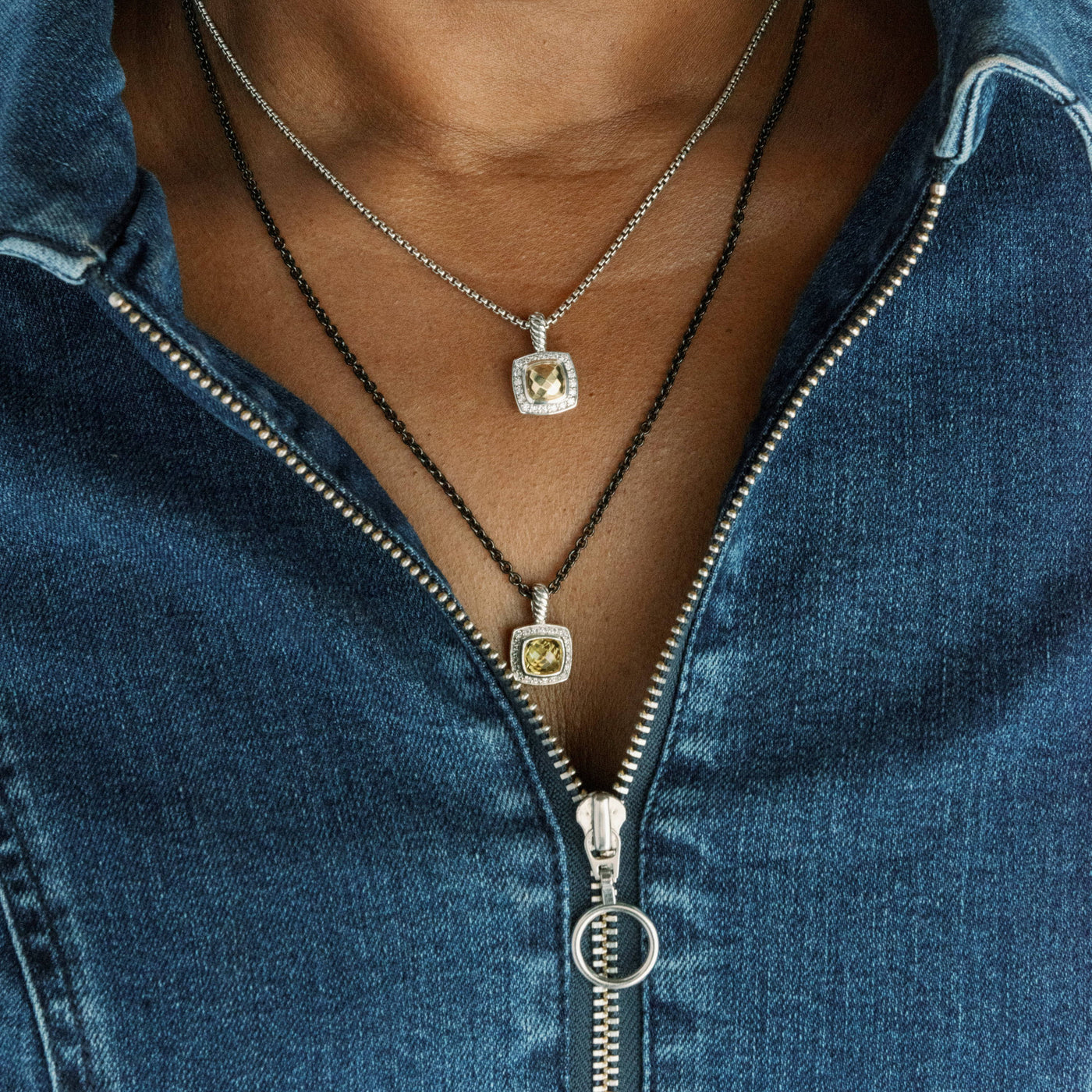 Woman wearing 2 layered citrine necklaces and a denim zippered shirt