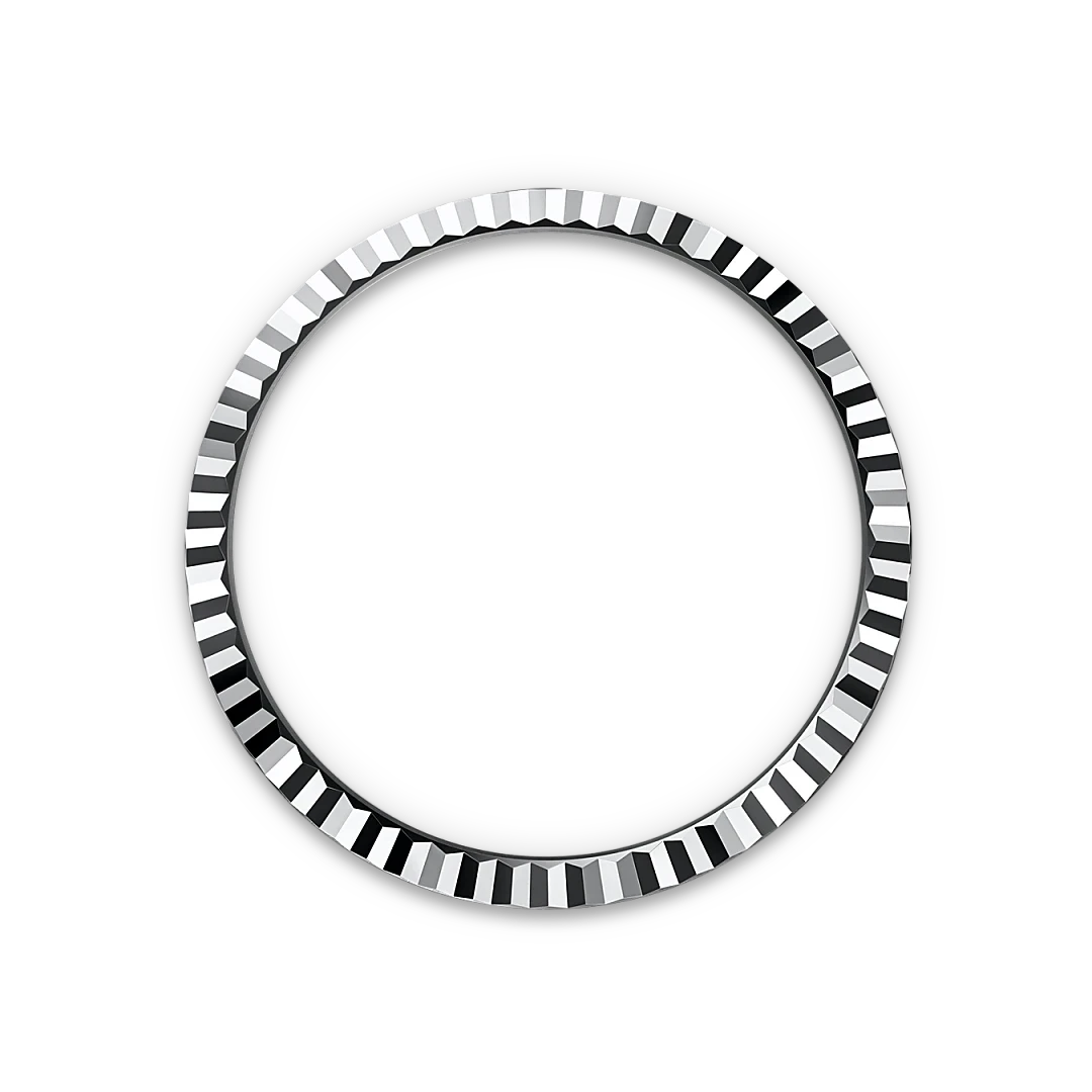 A detailed silver bezel ring with a faceted design, shown against a black background, highlighting its polished luxury jewelry craftsmanship.