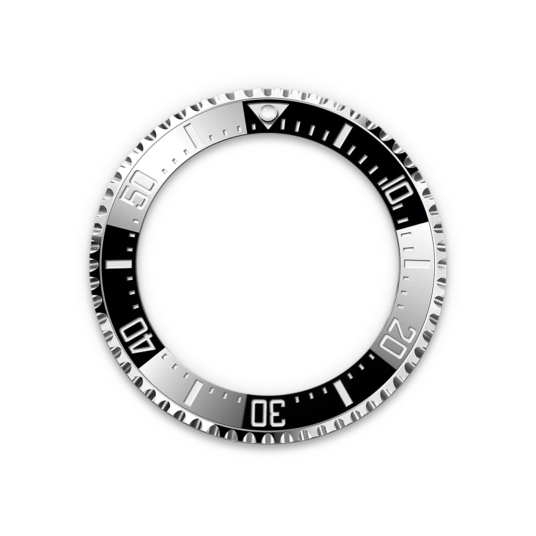 Silver and black rotating bezel from a luxury watch, featuring engraved minute markers and a luminous triangle at the 12 o'clock position, showcasing precise craftsmanship.