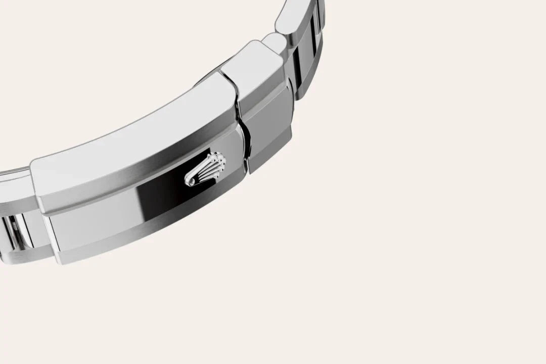 Close-up of a polished silver watch clasp featuring a distinctive crown logo, representing fine craftsmanship and luxury jewelry expertise.