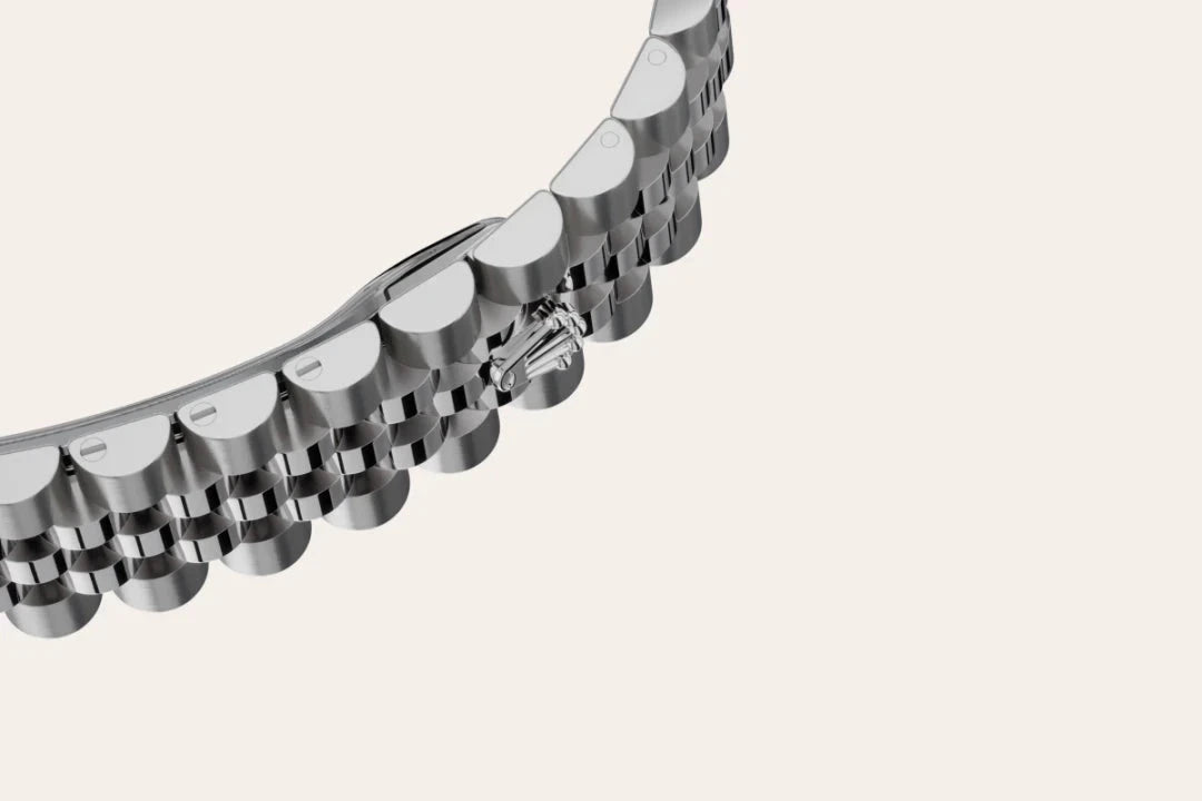 Close-up of a polished stainless steel watch bracelet with a distinctive logo clasp, highlighting fine craftsmanship and luxury jewelry design.