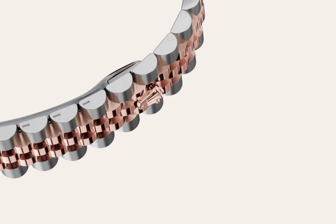 Close-up view of a two-tone metal watch bracelet with polished silver and rose gold links, showcasing detailed craftsmanship on a neutral background.