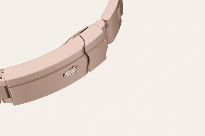 Close-up of a rose gold watch clasp featuring the iconic Rolex crown logo, showcasing fine craftsmanship and luxury jewelry design.