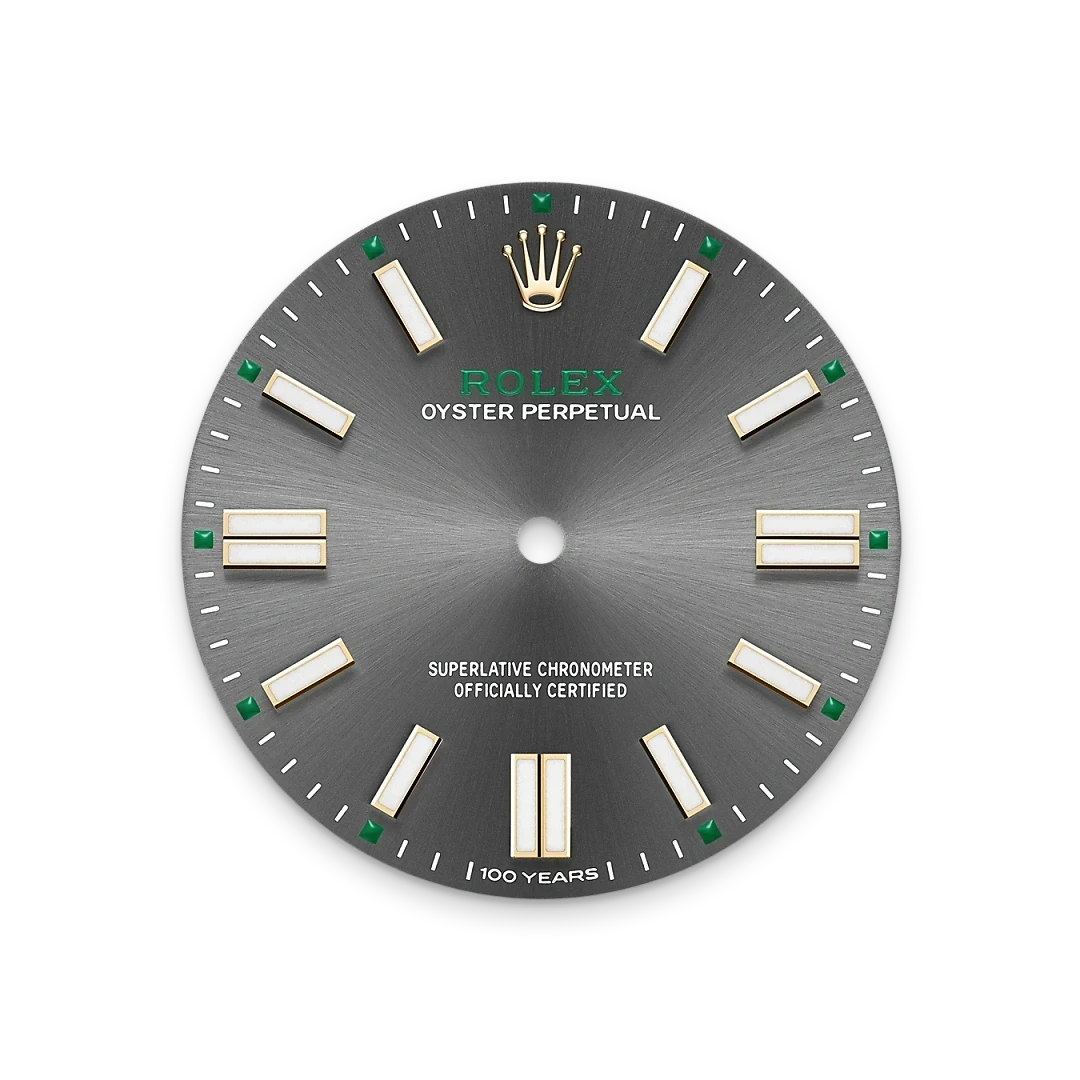 Close-up of a Rolex Oyster Perpetual watch dial in gray with gold hour markers, green accents, and the Rolex crown logo, highlighting precision and luxury craftsmanship.