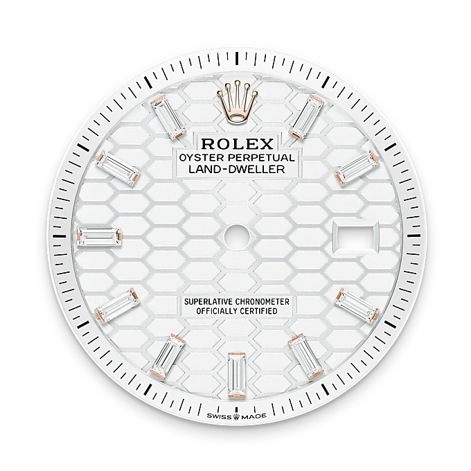 Rolex Land-Dweller watch face with white honeycomb pattern, baguette diamond hour markers, gold Rolex crown logo, and date window positioned at 3 o'clock.