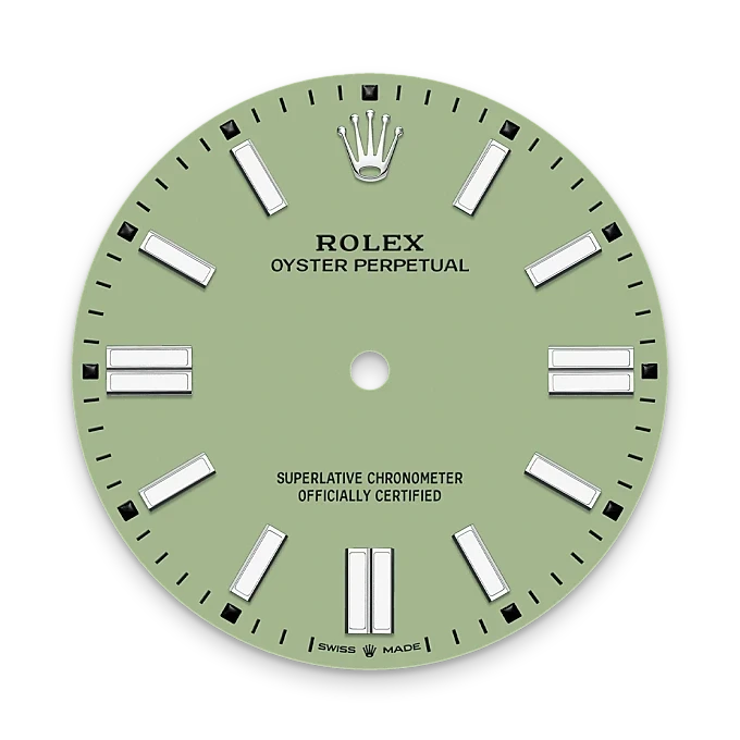 Rolex Oyster Perpetual watch dial in soft green with silver hour markers, featuring the Rolex crown logo and text indicating superlative chronometer certification.
