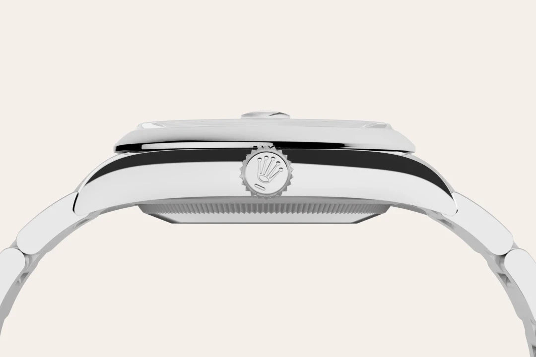 Side profile of a polished luxury watch with a stainless steel case and bracelet, featuring a crown with a distinctive logo, highlighting its sleek, elegant design.