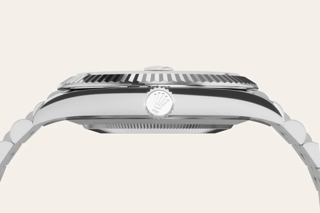 Side profile view of a silver luxury watch featuring a ridged bezel, polished metal casing, and a crown with an embossed logo on a linked metal bracelet.