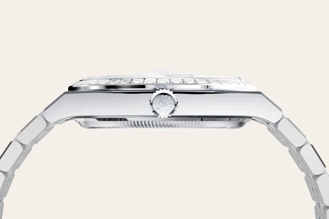 Side profile of a sleek silver luxury watch with a polished metal bracelet and a crown featuring a subtle logo, highlighting fine craftsmanship and design.