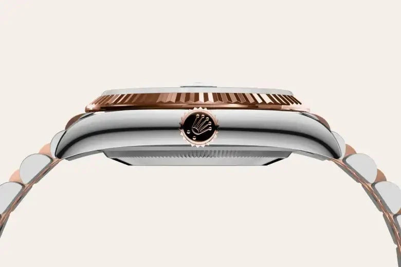Side profile of a luxury watch case and bracelet in stainless steel and rose gold with a fluted bezel and a branded crown, showcasing fine craftsmanship and elegant design.