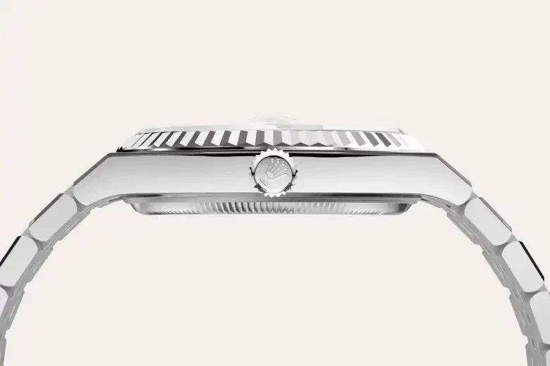 Side profile view of a polished luxury watch case and bracelet with a grooved bezel and a knurled crown, showcasing fine craftsmanship and sleek design.