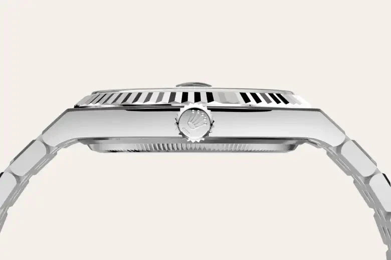 Close-up side view of a luxury stainless steel watch with a ridged bezel and a detailed crown, highlighting fine craftsmanship and precision design.