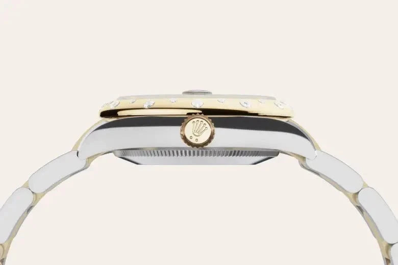 Close-up side view of a luxury two-tone Rolex watch featuring a gold bezel with diamonds and a detailed crown, showcasing fine craftsmanship and elegant design.