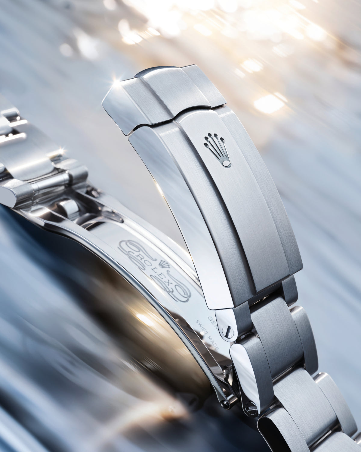 Close-up of a stainless steel Rolex watch clasp showing the engraved crown logo with a polished finish, highlighting fine craftsmanship and luxury watch detailing.