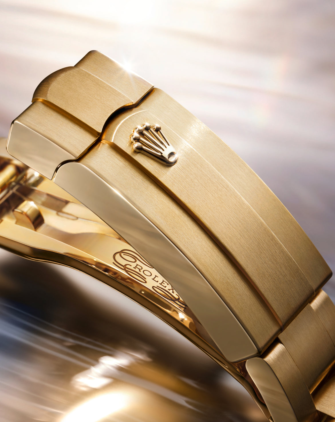 Close-up of a gold Rolex watch clasp featuring the iconic crown logo, highlighting fine craftsmanship and luxury details in a polished metal finish.