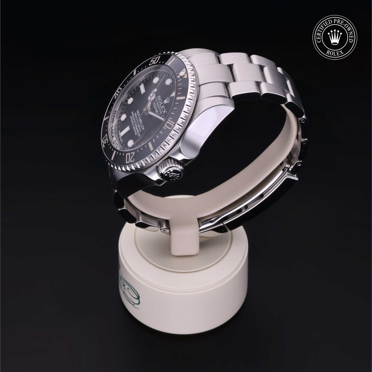 Rolex luxury watch with stainless steel bracelet displayed on a white stand against a black background, featuring a Certified Pre-Owned Rolex logo in the corner.