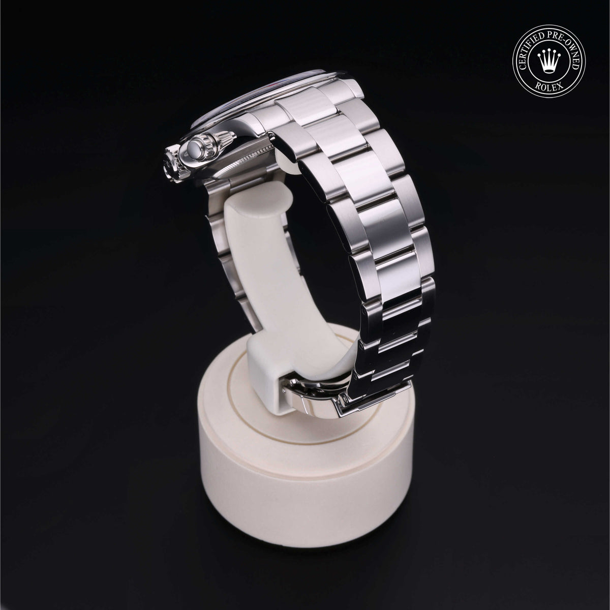 Stainless steel luxury wristwatch bracelet displayed on a white stand with a 