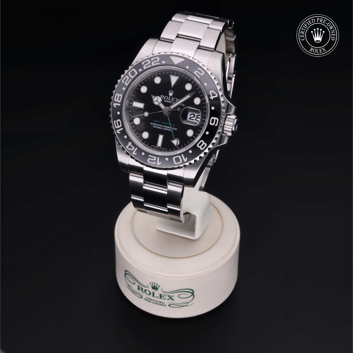 Rolex stainless steel luxury watch with black dial and date display, shown on a branded stand with a certified pre-owned Rolex logo, highlighting fine watch craftsmanship.