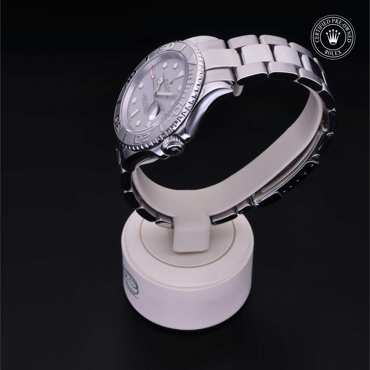 Side view of a silver luxury watch displayed on a white stand with a Rolex Certified Pre-Owned logo in the corner, highlighting fine craftsmanship and timeless design.