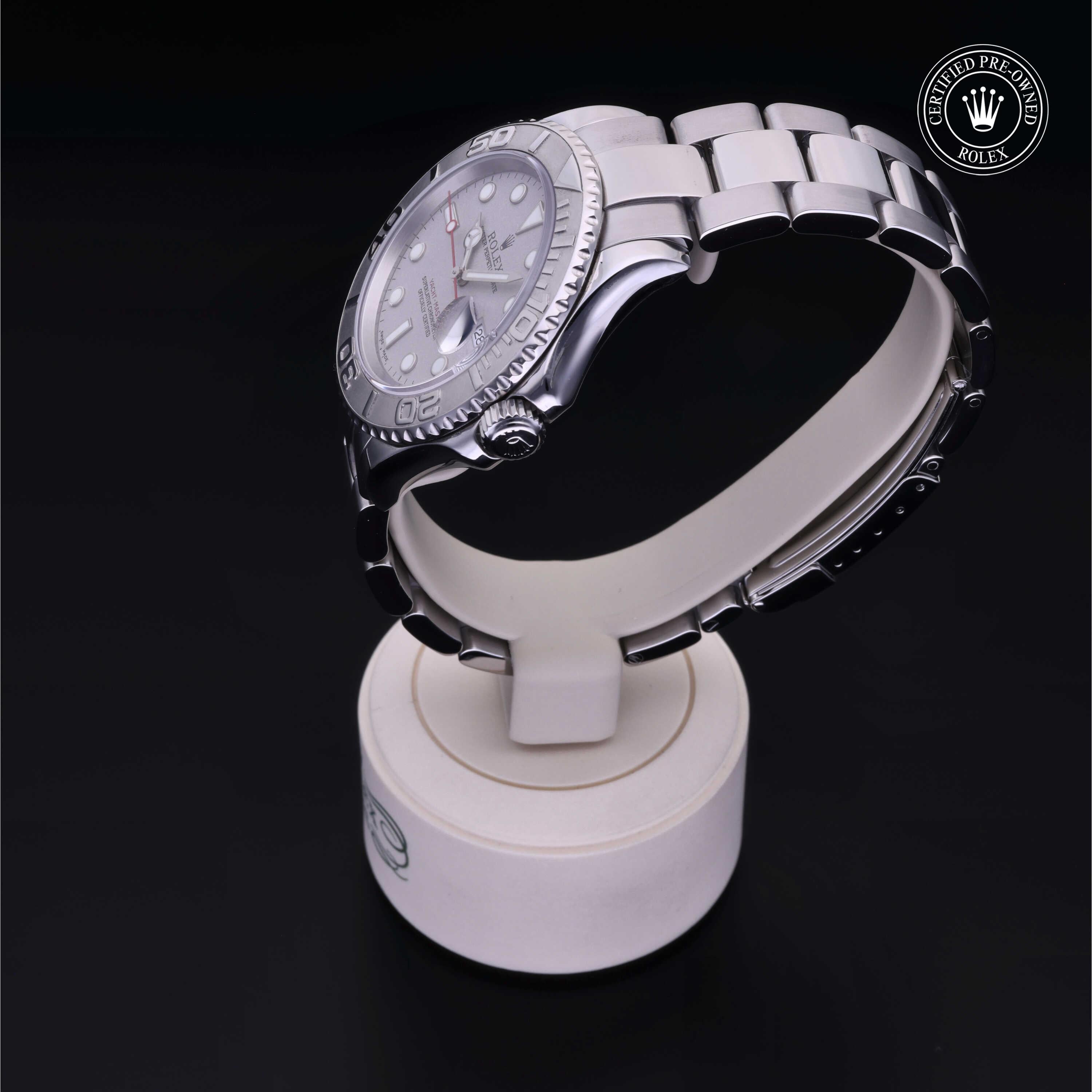 Side view of a silver luxury watch displayed on a white stand with a Rolex Certified Pre-Owned logo in the corner, highlighting fine craftsmanship and timeless design.