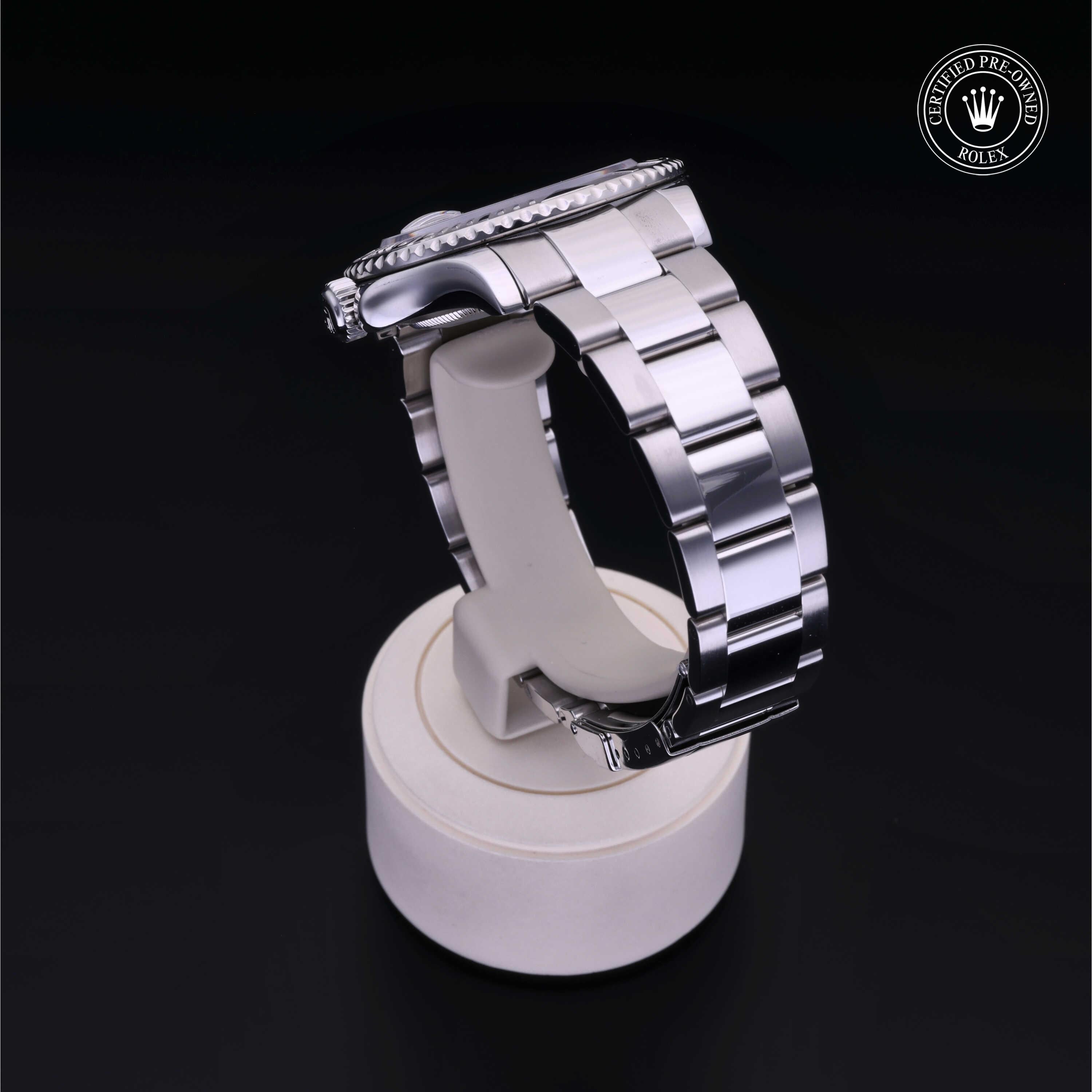 Silver stainless steel Rolex watch with a polished link bracelet displayed on a white stand against a black background, featuring a Rolex Certified Pre-Owned logo.