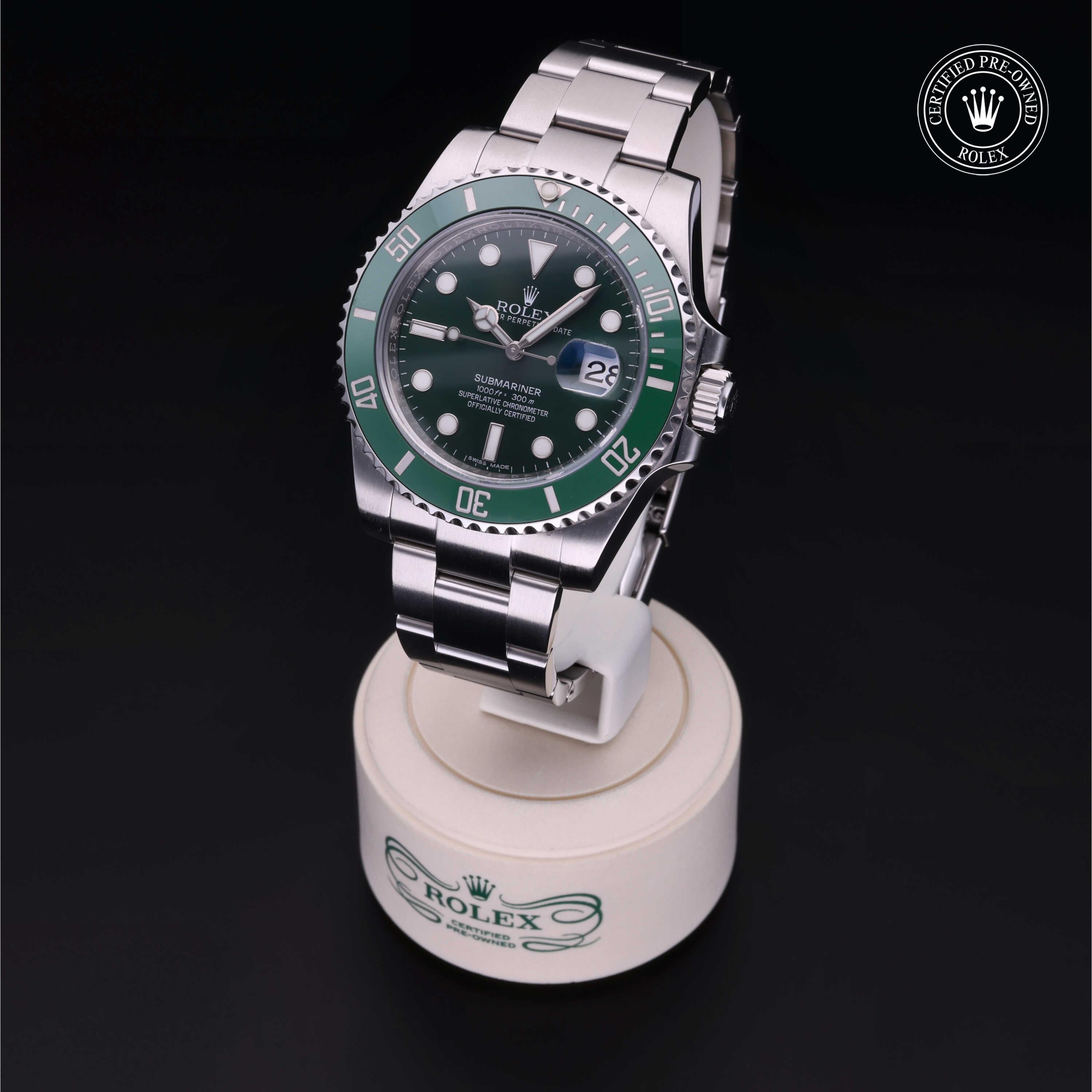 Rolex Submariner luxury watch with green bezel and black dial displayed on a white stand, featuring the Rolex Certified Pre-Owned logo in the corner.