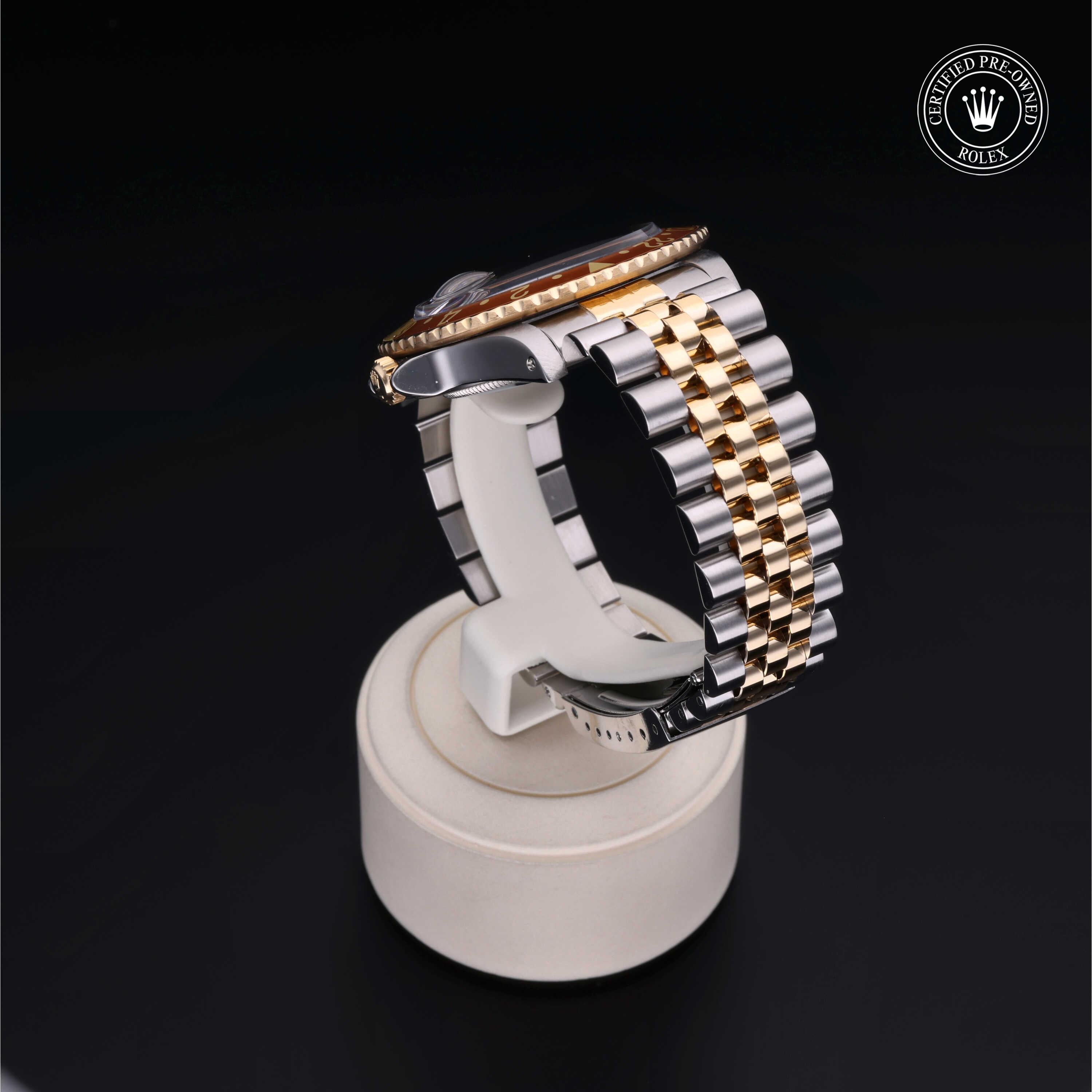 Two-tone luxury watch with a gold and silver metal link bracelet displayed on a white stand against a black background, featuring a certified pre-owned Rolex logo.