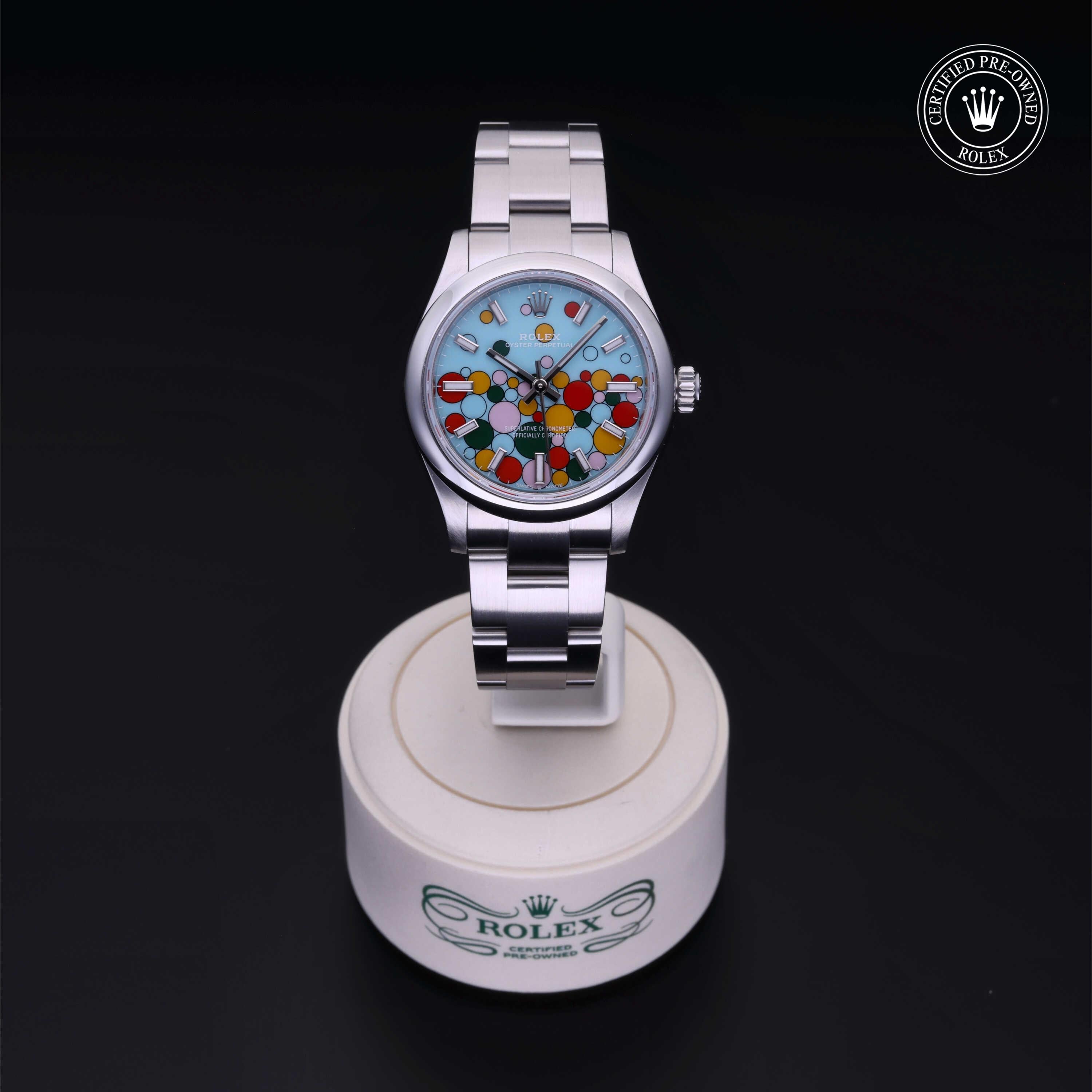 Rolex Certified Pre-Owned stainless steel watch with a playful multicolored dial on a white stand featuring the Rolex logo, highlighting luxury and fine craftsmanship.