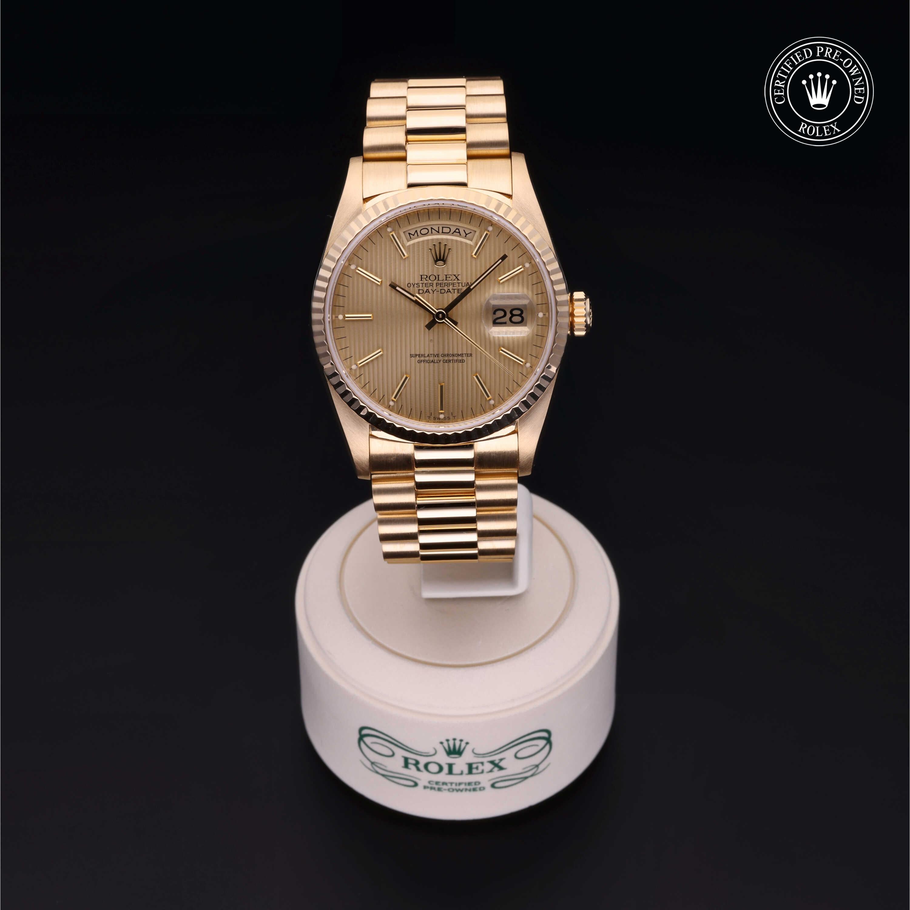 Gold Rolex wristwatch with a fluted bezel and date display on a white stand, featuring the Rolex Certified Pre-Owned emblem on a dark background.