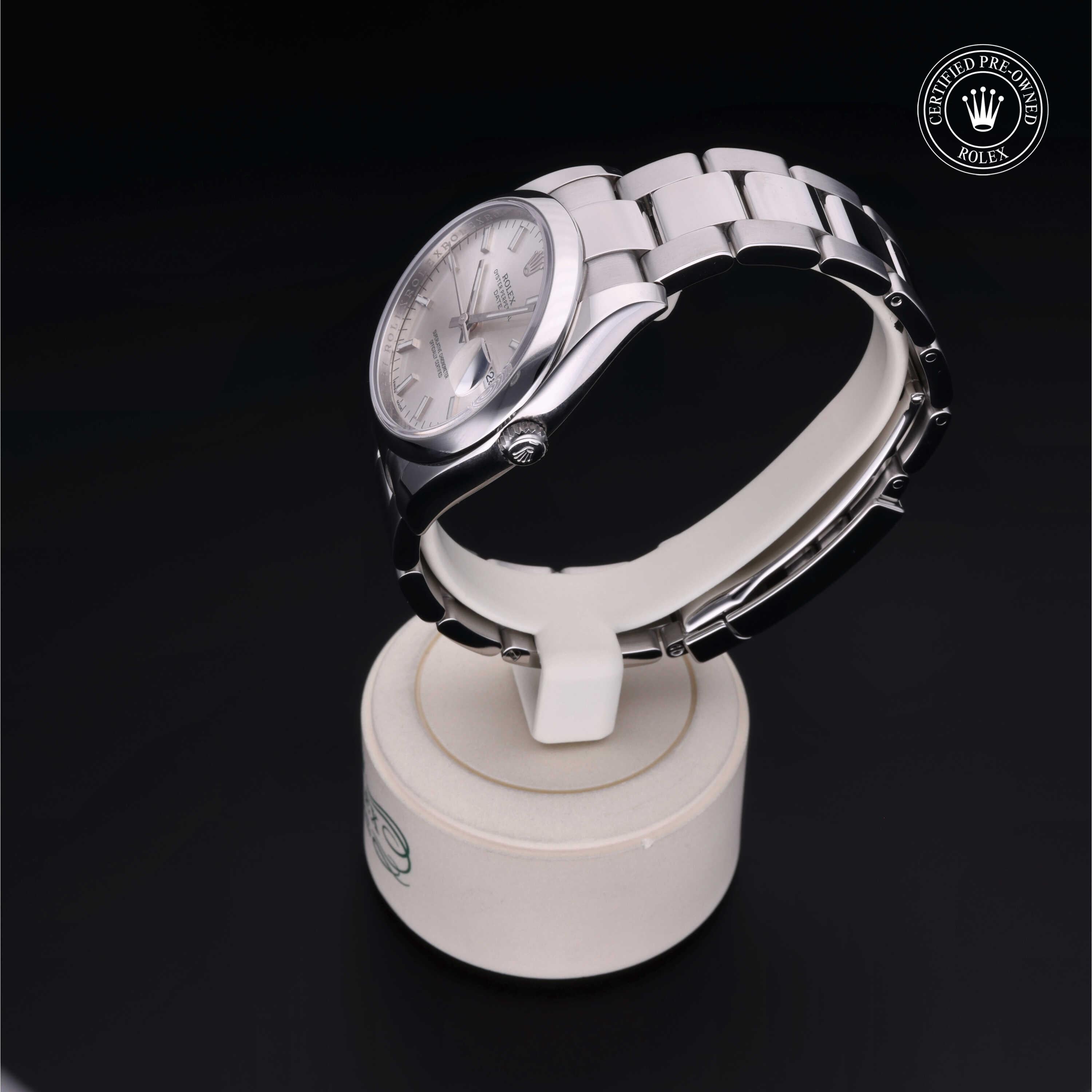 Silver Rolex luxury watch with metal link band displayed on a white stand, featuring a Rolex Certified Pre-Owned logo on a black background, highlighting fine craftsmanship.