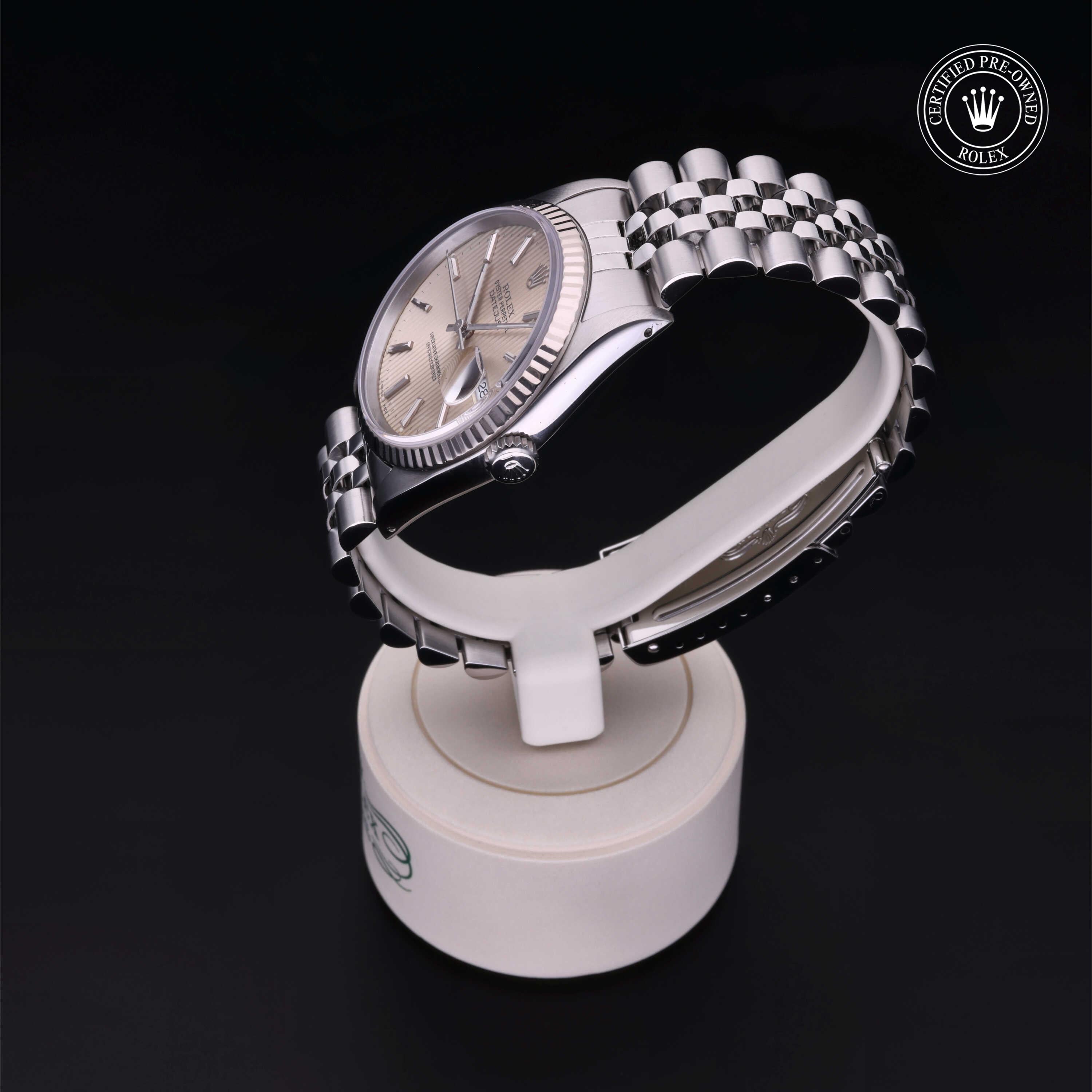 Silver Rolex watch with a Jubilee bracelet displayed on a white stand, featuring the 