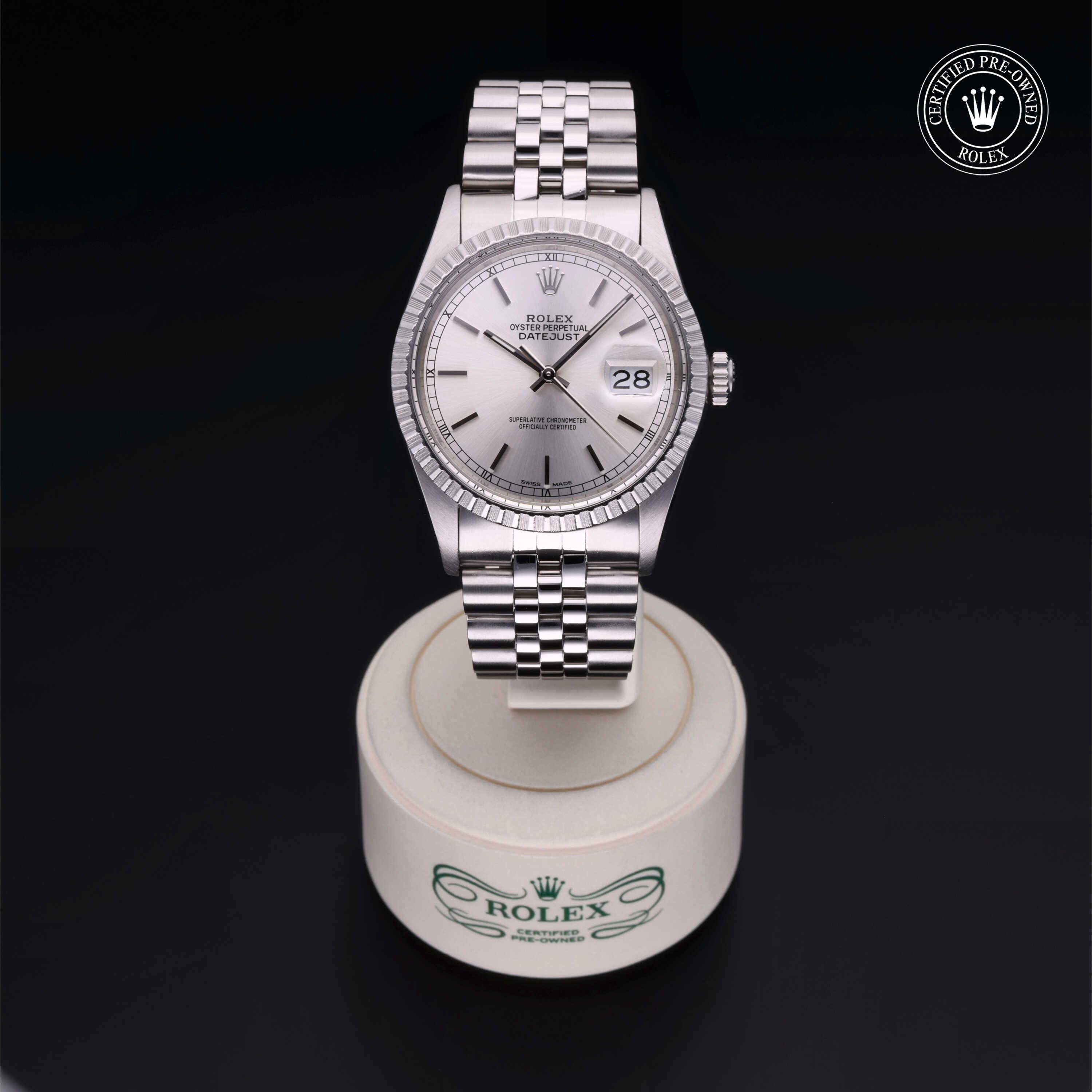 Silver Rolex Datejust wristwatch with a Jubilee bracelet displayed on a white stand, featuring a date window and Rolex Certified Pre-Owned logo, representing luxury jewelry.