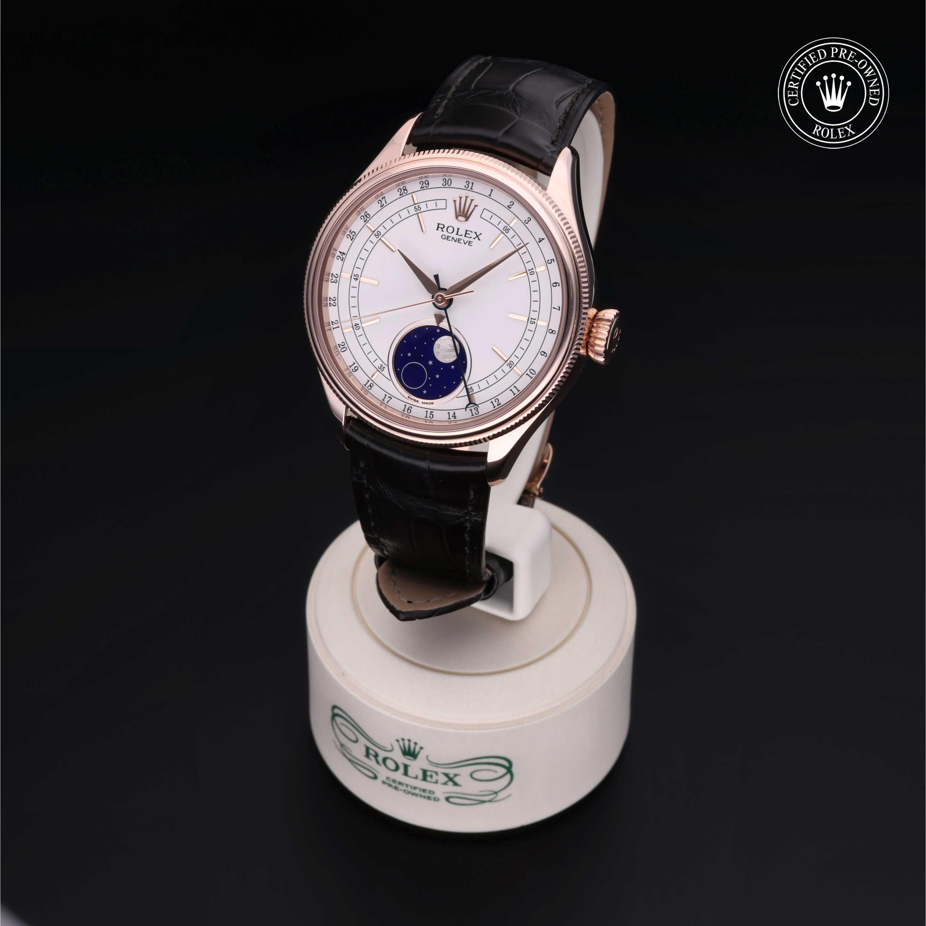 Rolex Certified Pre-Owned luxury watch with rose gold case, white dial featuring moonphase display, and black leather strap displayed on branded stand, showcasing fine craftsmanship and elegance.