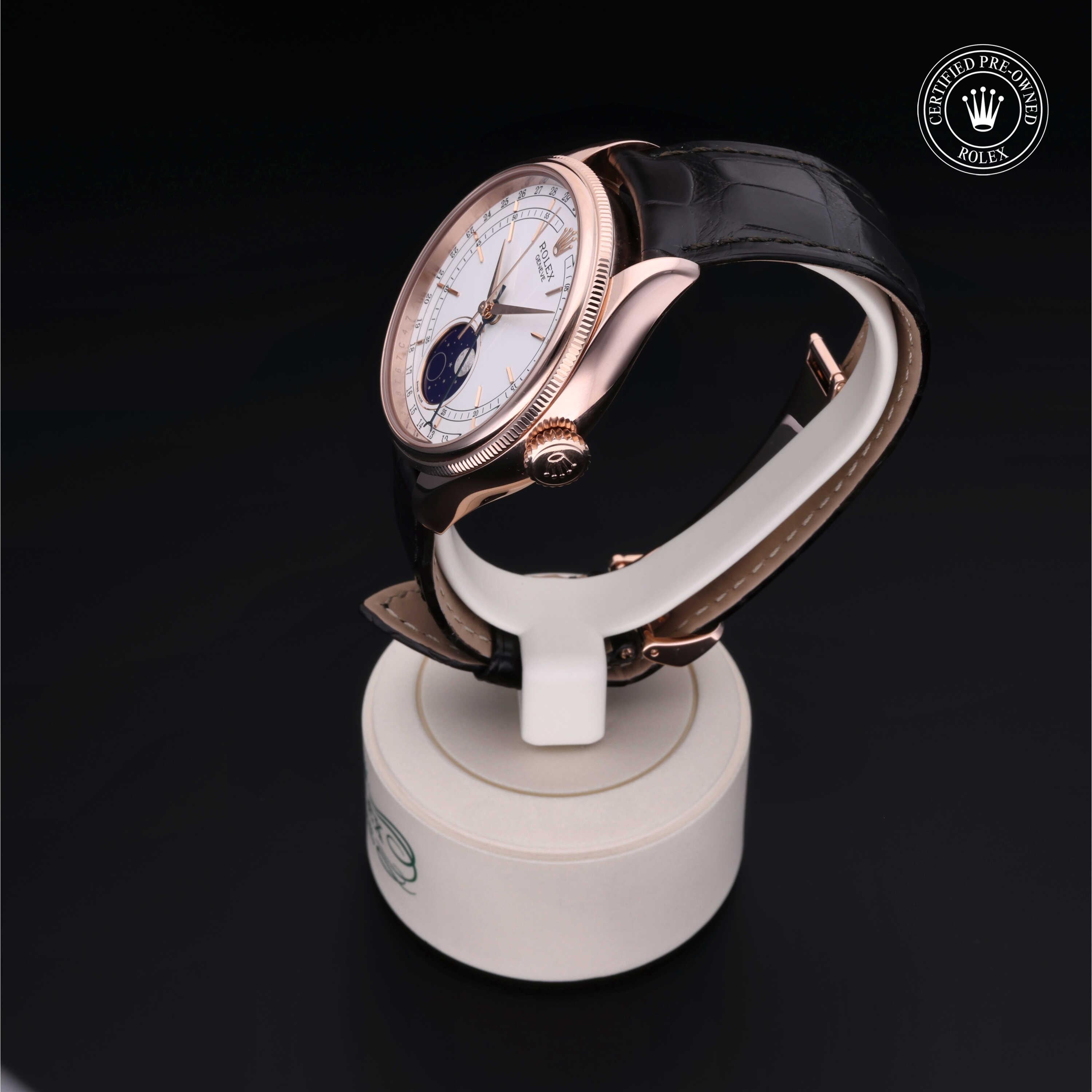 Side view of a luxury Rolex watch with a rose gold case, white dial, and black leather strap displayed on a white stand against a dark background, featuring a certified pre-owned logo.