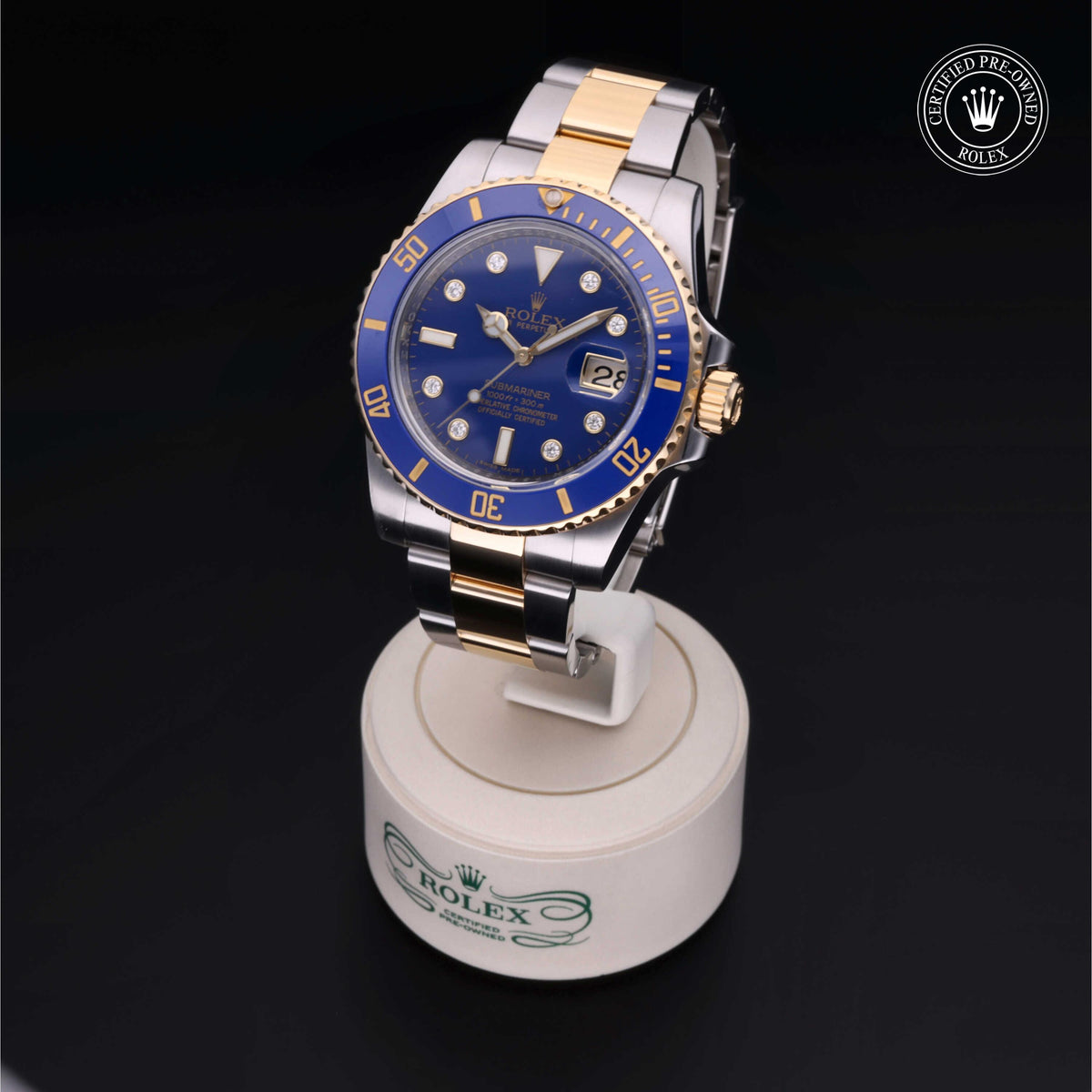 Two-tone Rolex luxury watch with blue dial and gold markers displayed on a branded stand, highlighting fine craftsmanship and Rolex Certified Pre-Owned status.