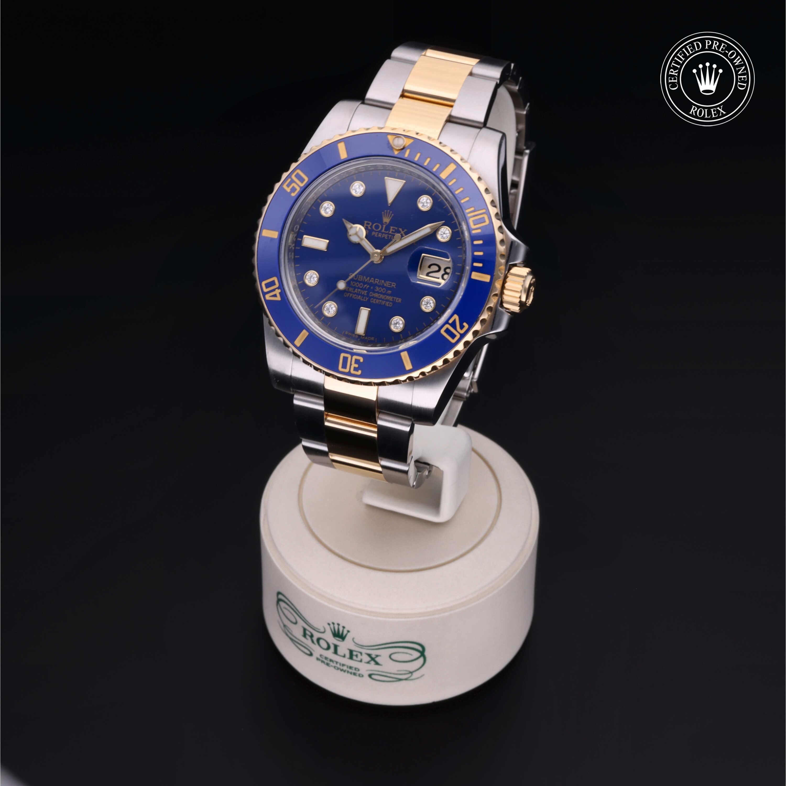 Two-tone Rolex luxury watch with blue dial and gold markers displayed on a branded stand, highlighting fine craftsmanship and Rolex Certified Pre-Owned status.