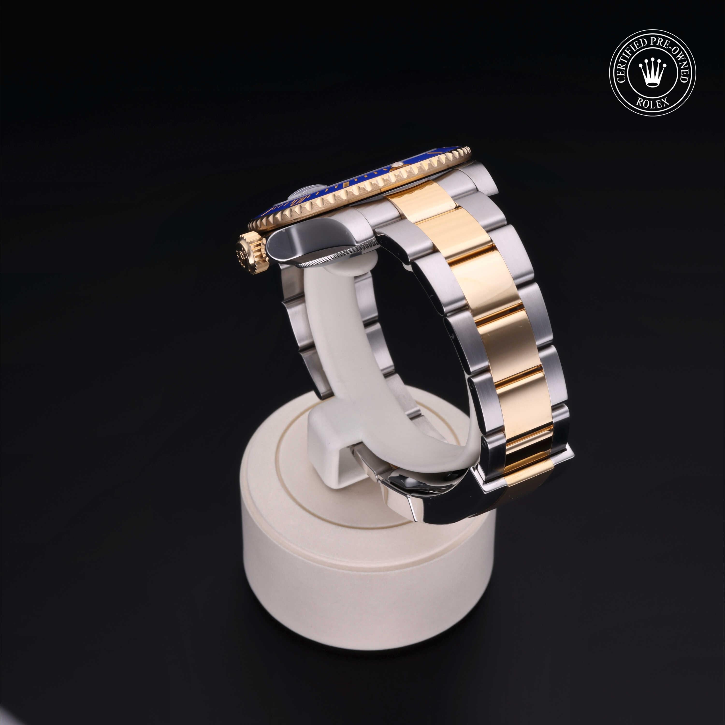 Two-tone luxury wristwatch with a gold and silver metal band displayed on a white stand against a black background, featuring a Rolex Certified Pre-Owned emblem.