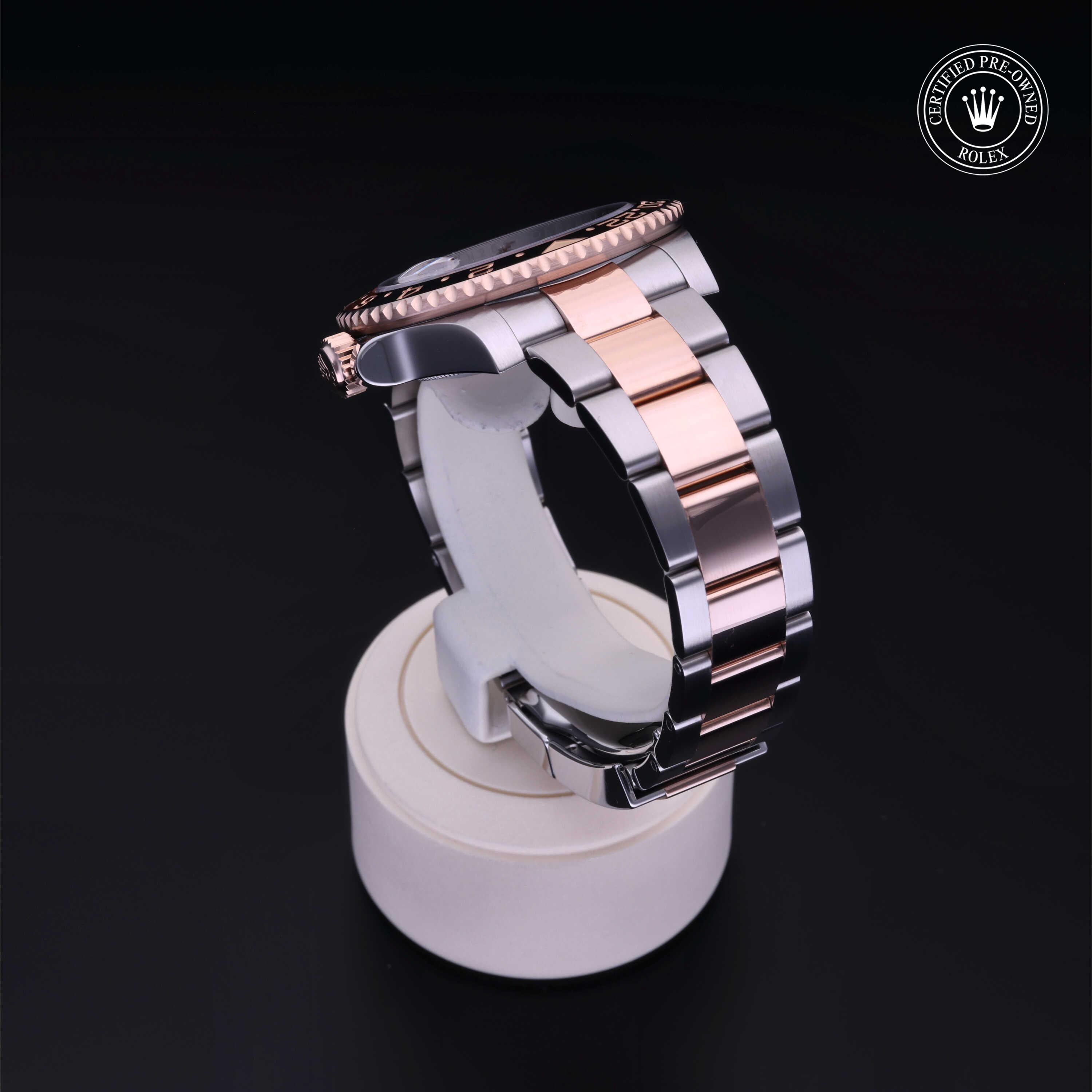 Side view of a two-tone luxury watch with a silver and rose gold metal band displayed on a white stand against a black background, featuring a Certified Pre-Owned Rolex logo.