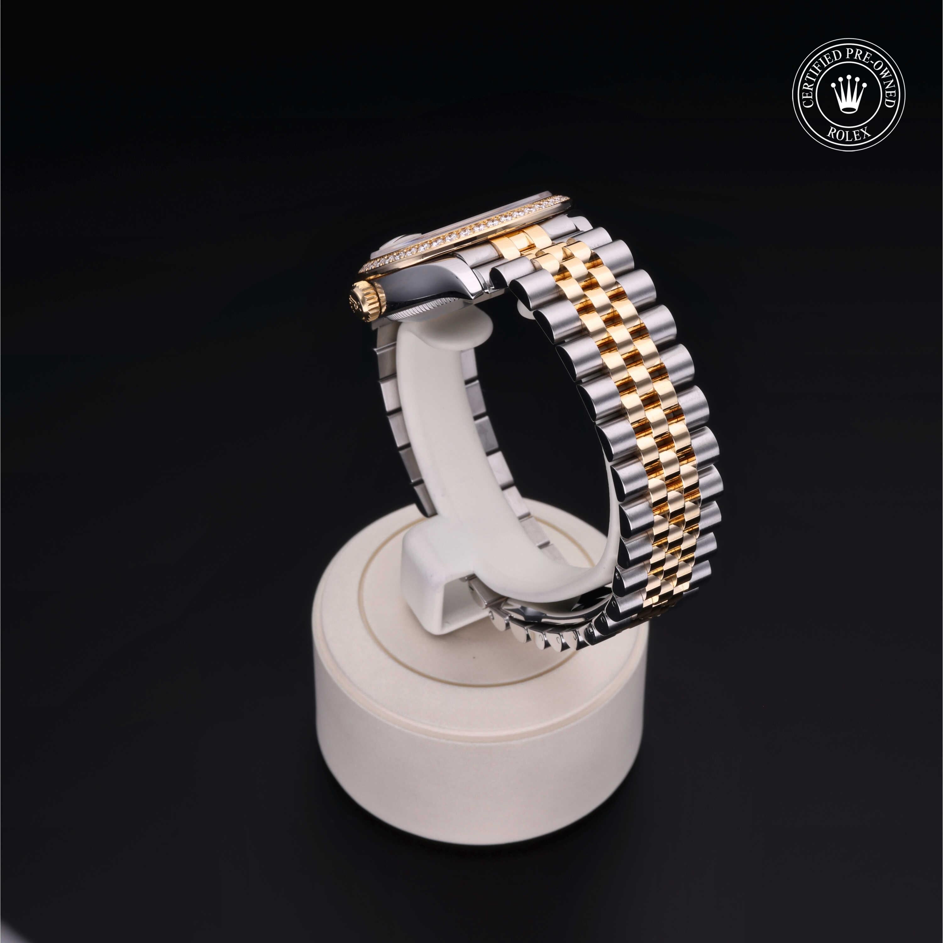 Two-tone luxury watch with a gold and silver metal bracelet displayed on a white stand against a black background, featuring a certified pre-owned Rolex logo.