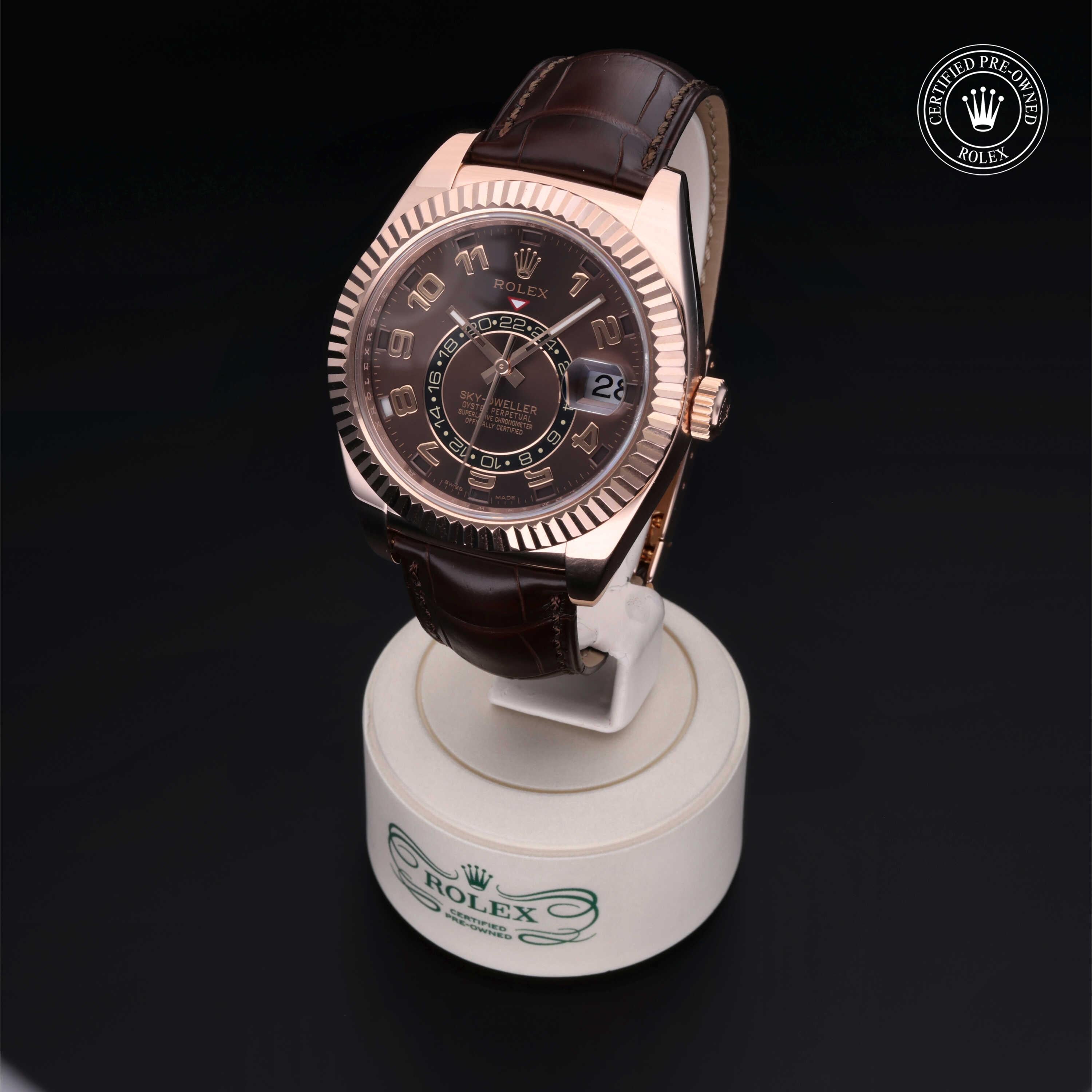 Luxury Rolex watch with a brown leather strap and rose gold bezel displayed on a branded stand, highlighting expert craftsmanship and certified pre-owned quality.