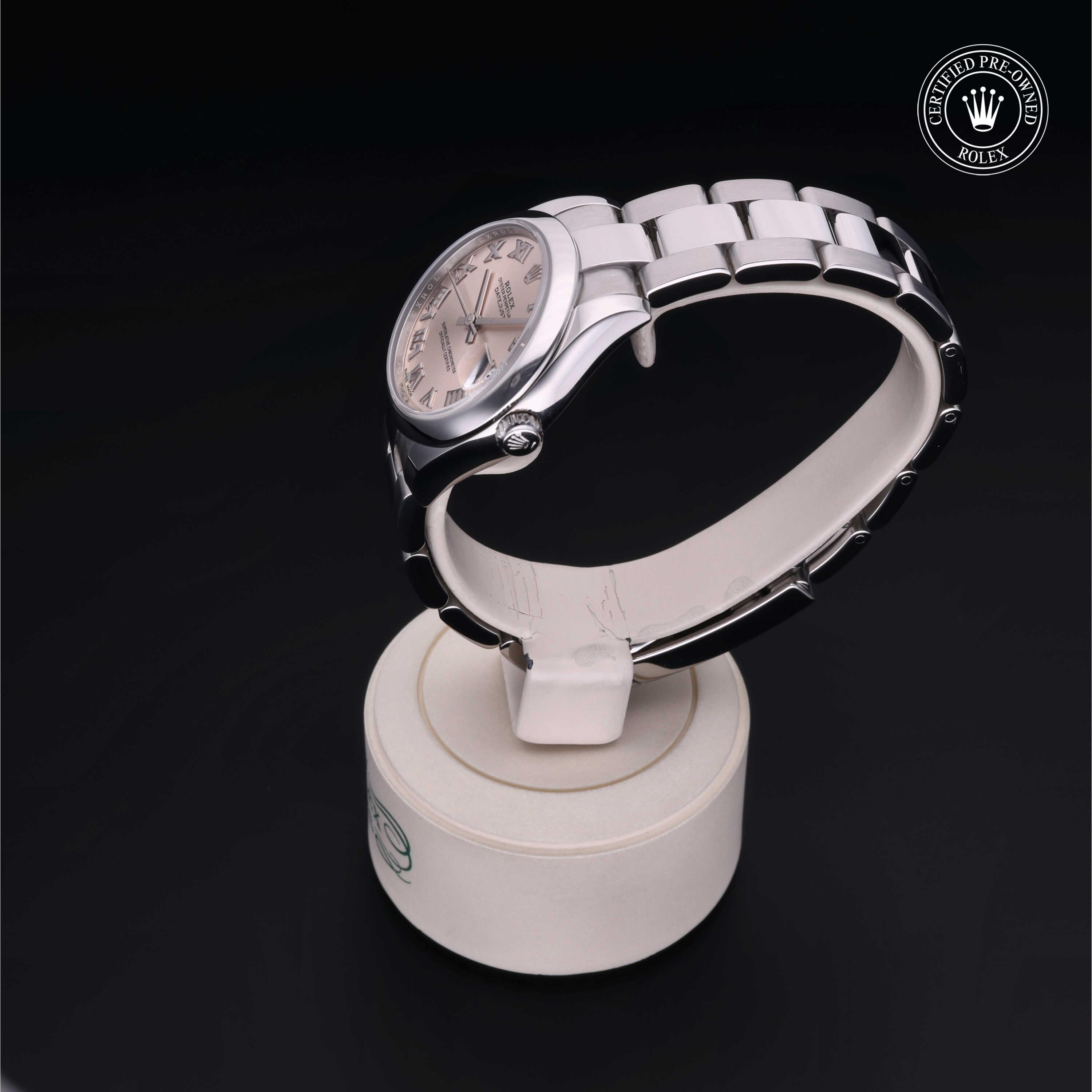 Silver Rolex luxury watch with a classic round face displayed on a white stand against a black background, featuring a Certified Pre-Owned Rolex logo in the corner.