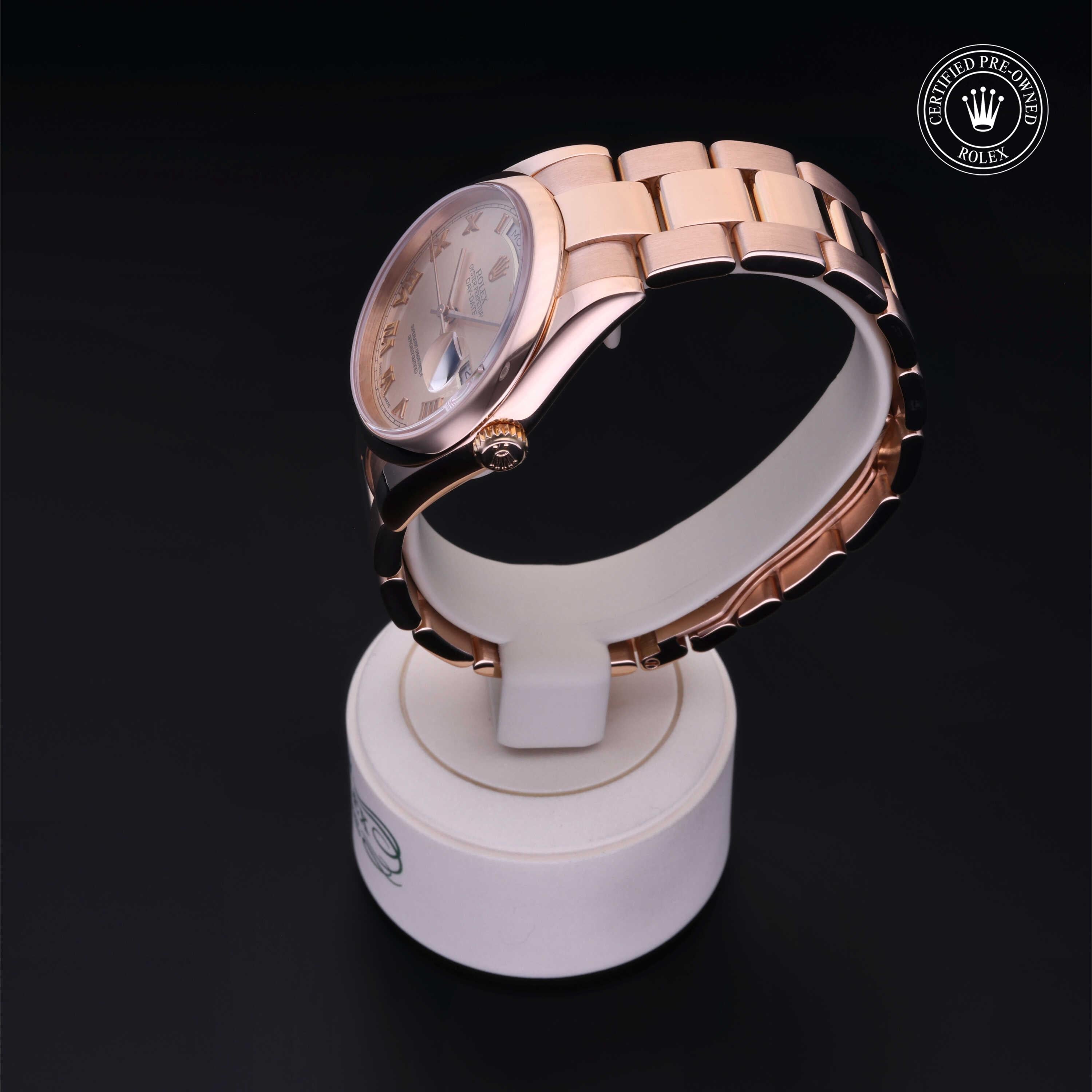 Rose gold Rolex watch displayed on a white stand against a black background with a Rolex Certified Pre-Owned emblem in the corner, highlighting luxury and expert care.