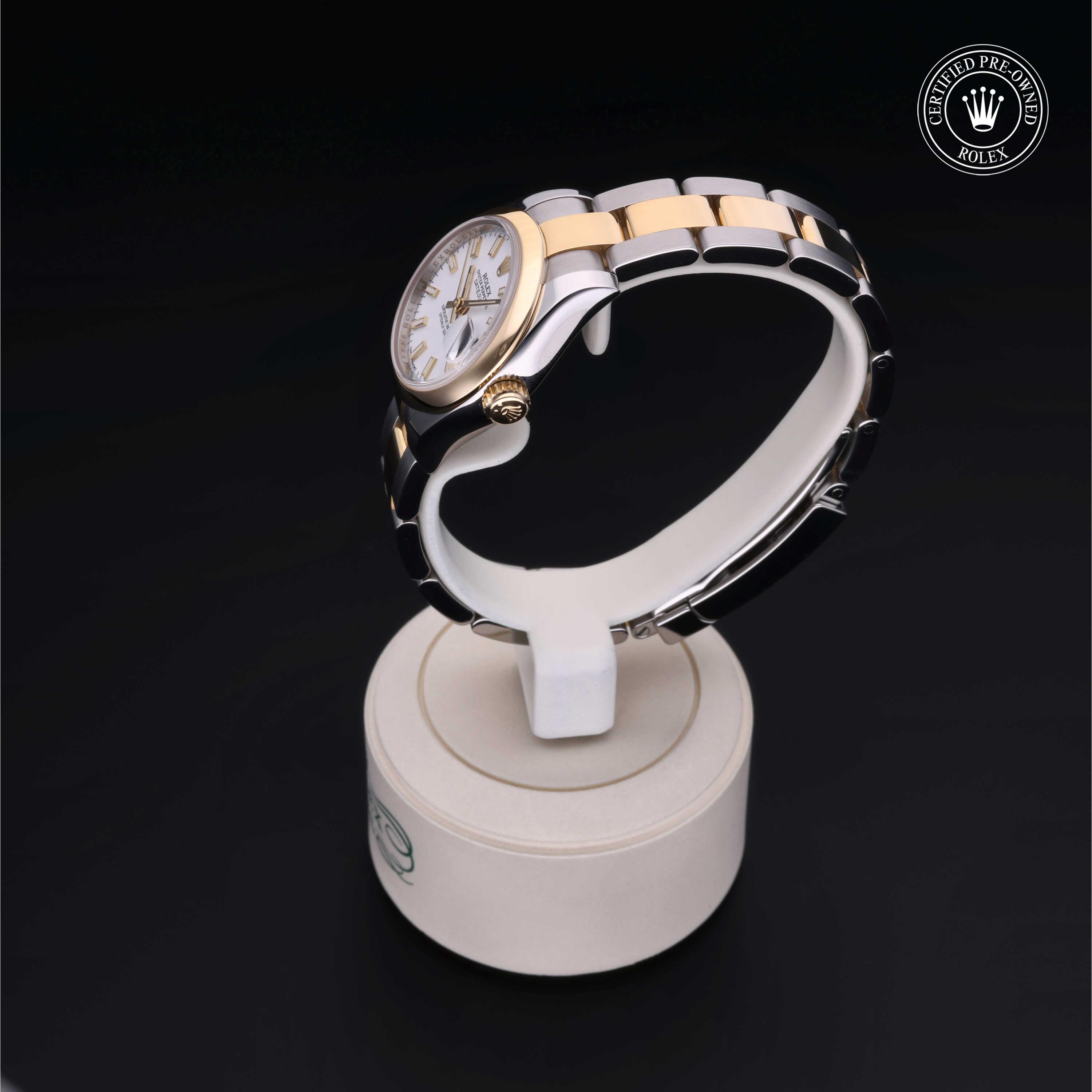 Two-tone luxury wristwatch with silver and gold links on a white display stand, featuring a white dial and a certified pre-owned Rolex logo in the corner.