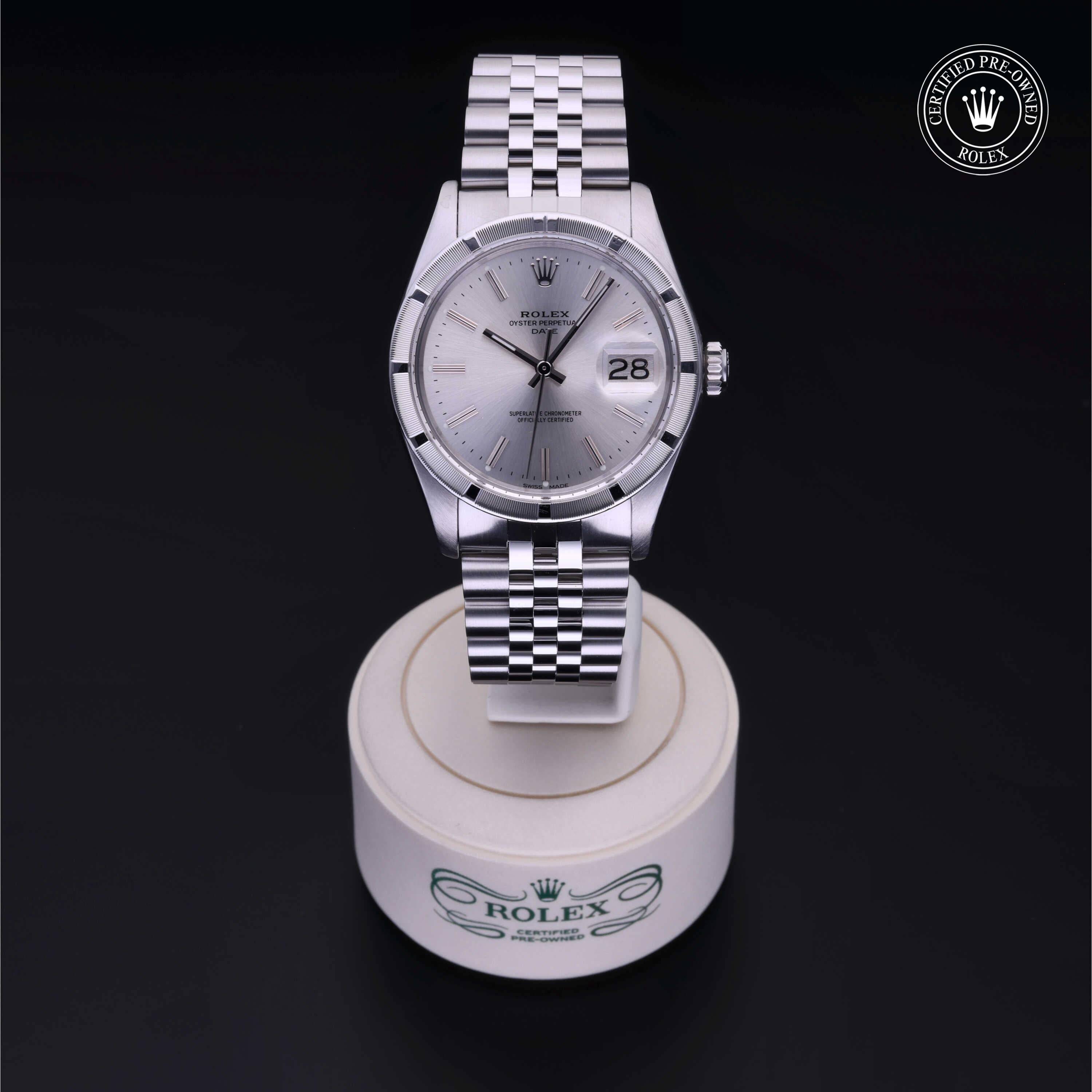 Silver Rolex Certified Pre-Owned wristwatch with a silver dial and date display, showcased on a white branded stand against a black background.