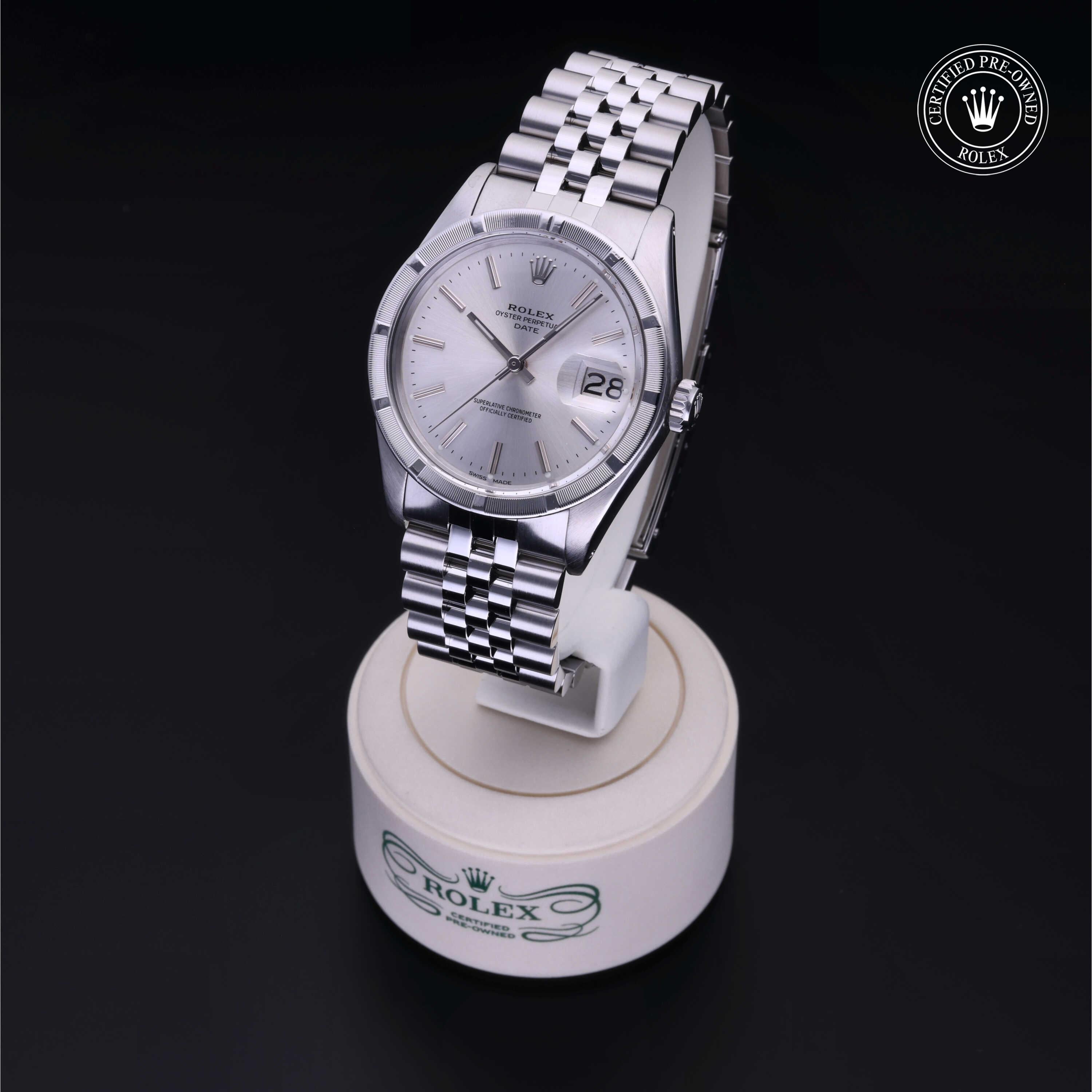 Silver Rolex watch with a stainless steel band displayed on a white Rolex stand against a black background, showcasing fine luxury watch craftsmanship.