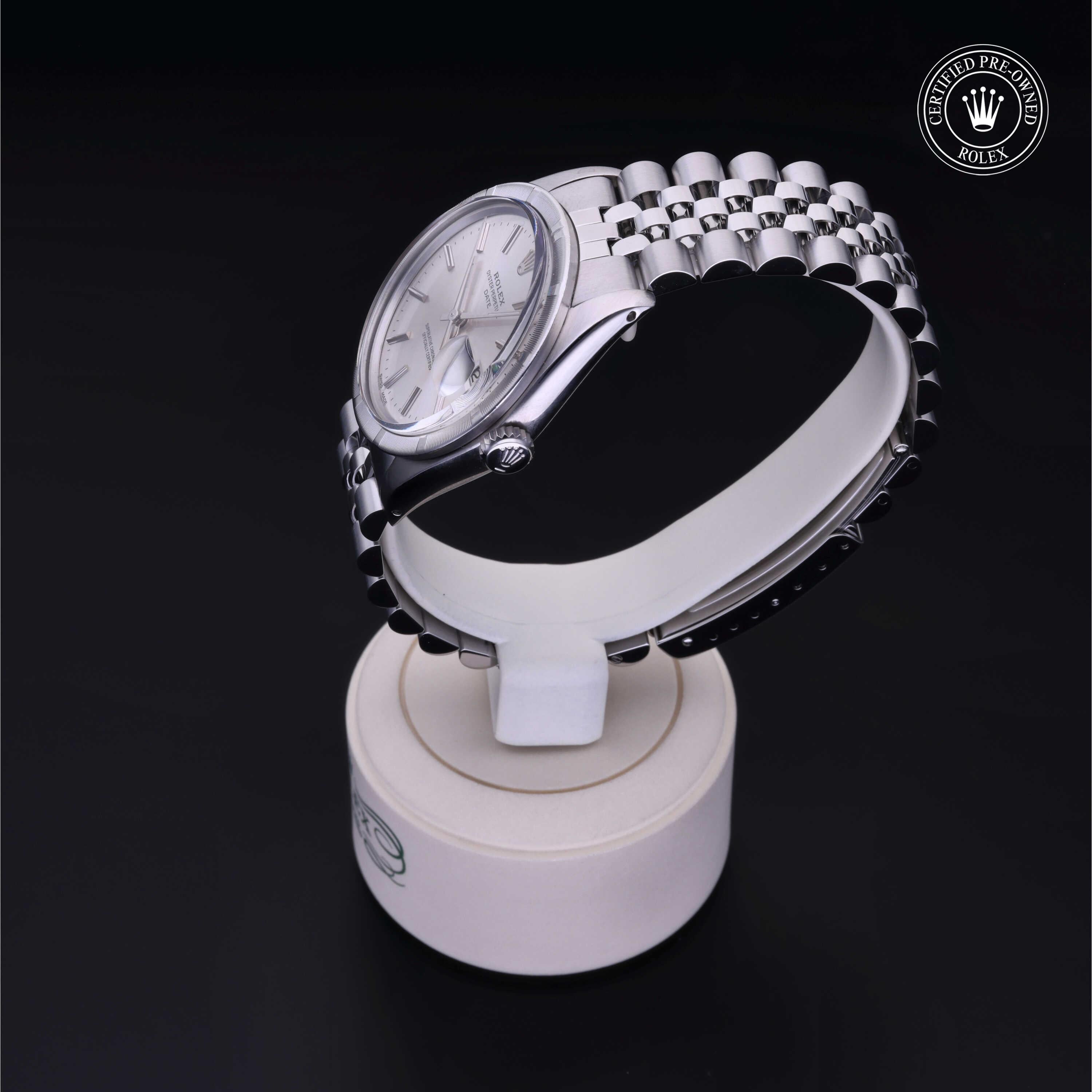 Silver Rolex luxury watch with a stainless steel Jubilee bracelet displayed on a white stand against a black background, featuring a certified pre-owned Rolex logo.