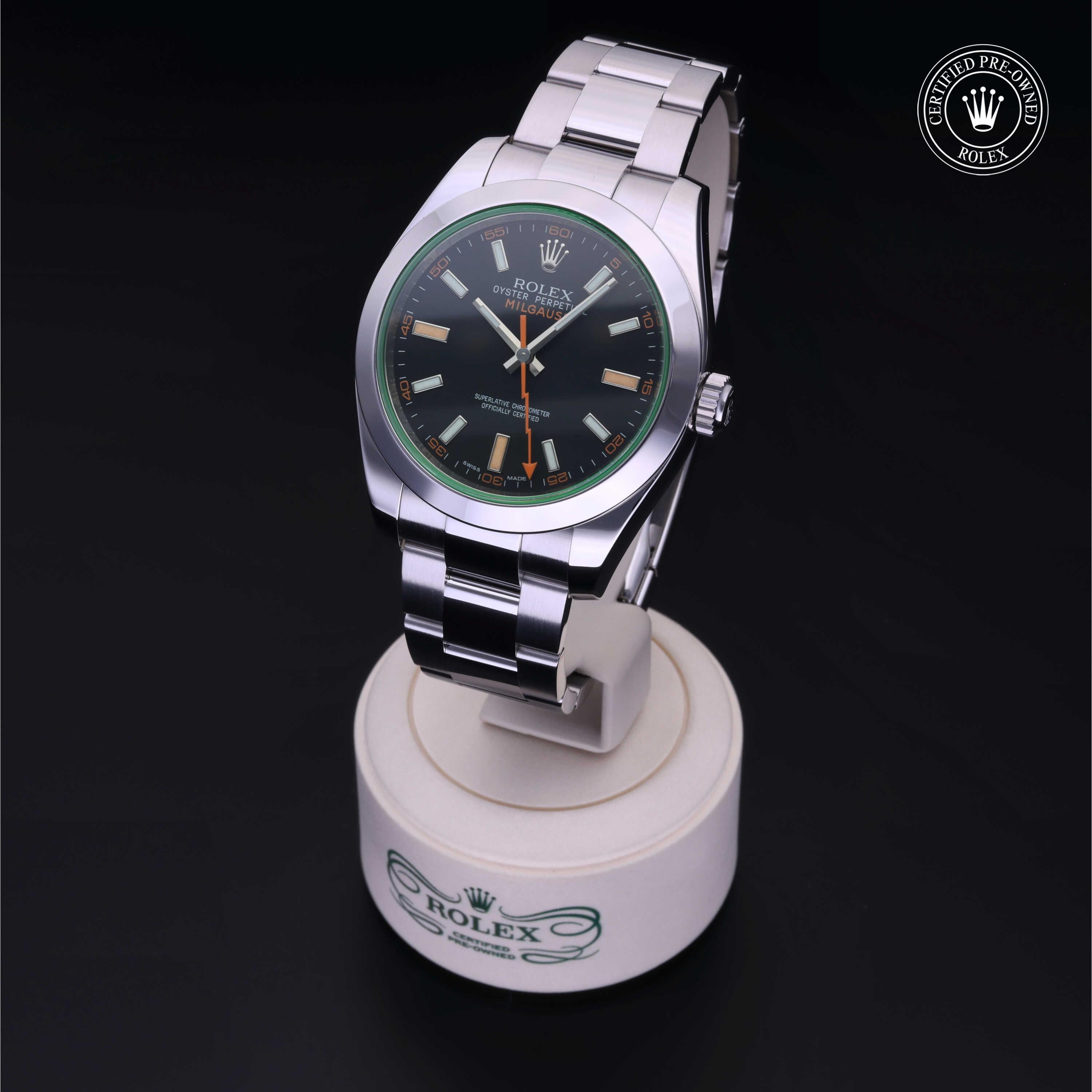 Rolex Milgauss watch with stainless steel bracelet displayed on a stand, featuring a black dial and green-tinted crystal, certified pre-owned by Henne Jewelers.
